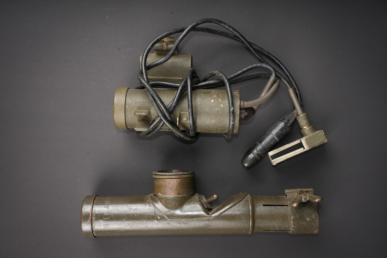 Lampes declairage de canon US. US gun illumination lamps: Lampes declairage de canon US. Comprenant une lampe en metal, peinture kaki a 70%. Partie basse incomplete. Toutes les pieces mobiles sont fonctionnelles. Filtre vert. Marquages Light Aiming Post M41.