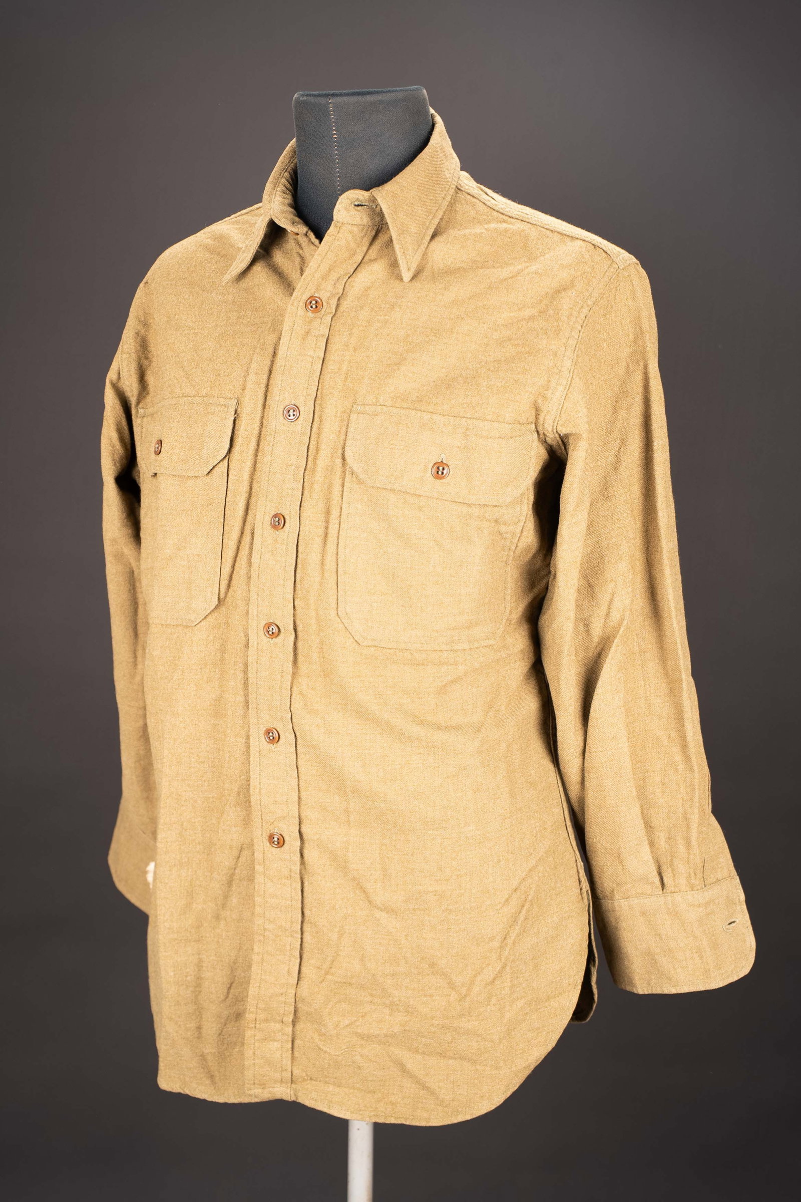 Chemise moutarde. US army shirt: Chemise moutarde. En drap de laine kaki. Tous les boutons sont presents. Modele sans bavette anti-gaz. Etiquette dans le col absente. Etiquette fabricant illisible. A noter une certaine usure et patin