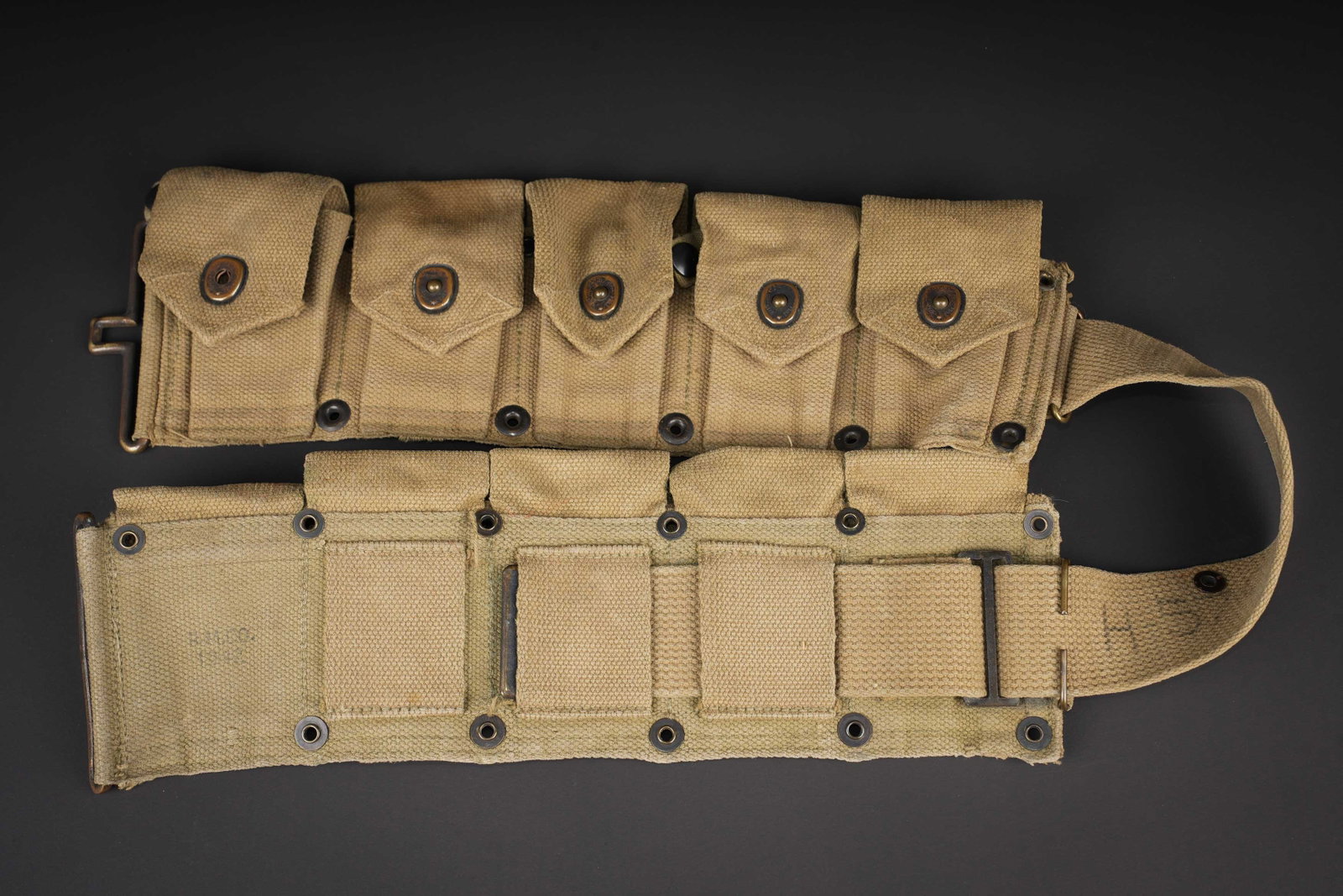 Ceinturon Garand US. US Army Garand belt.: Ceinturon Garand US. En forte toile OD, partiellement decolore par le soleil. Bouclerie en laiton. Tous les boutons pressions sont fonctionnels. Beau marquage US. Dix compartiments. Marquages presents