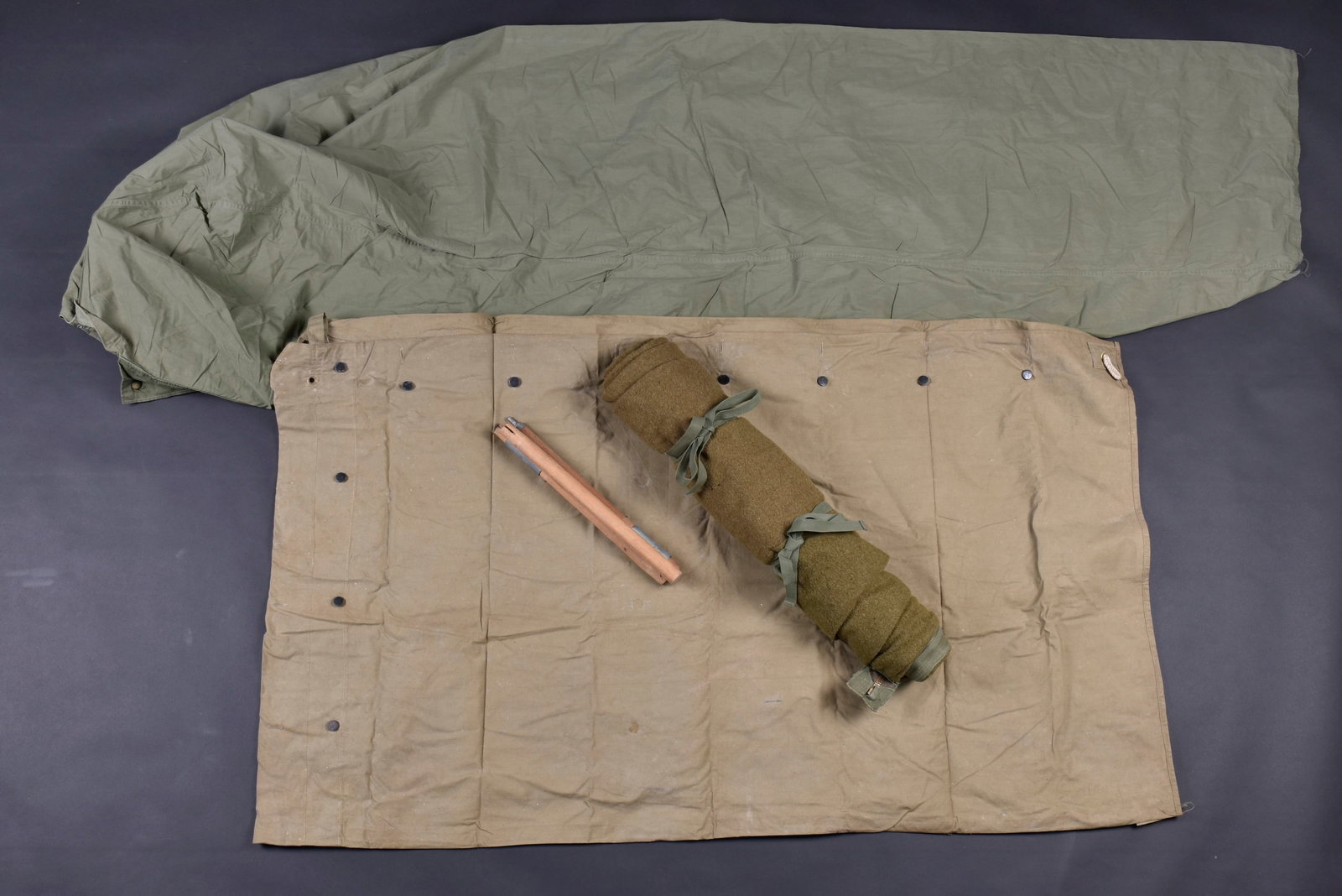 Accessoires de campement US. US Army camp equipment accessories.: Accessoires de campement US. Comprenant un mat de piquets de tente pliant, en bois et metal, sans marquages visibles. Une demi toile de tente en forte toile OD3, tous les boutons sont presents. Beau m