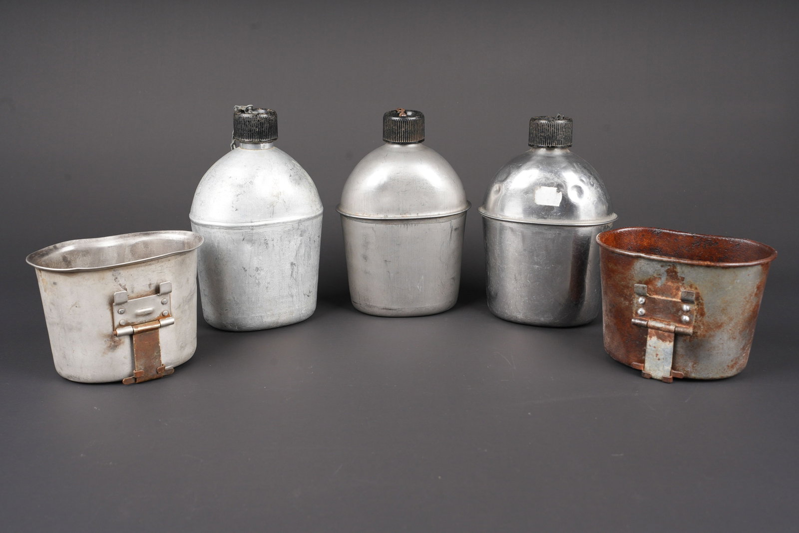 Gourdes US. US Army canteens.: Gourdes US. Comprenant une gourde en aluminium, bouchon et chainette presents, fabrication US RSE 1945. Un quart en aluminium, les marquages sont illisibles. Une gourde en aluminium, bouchon et chaine