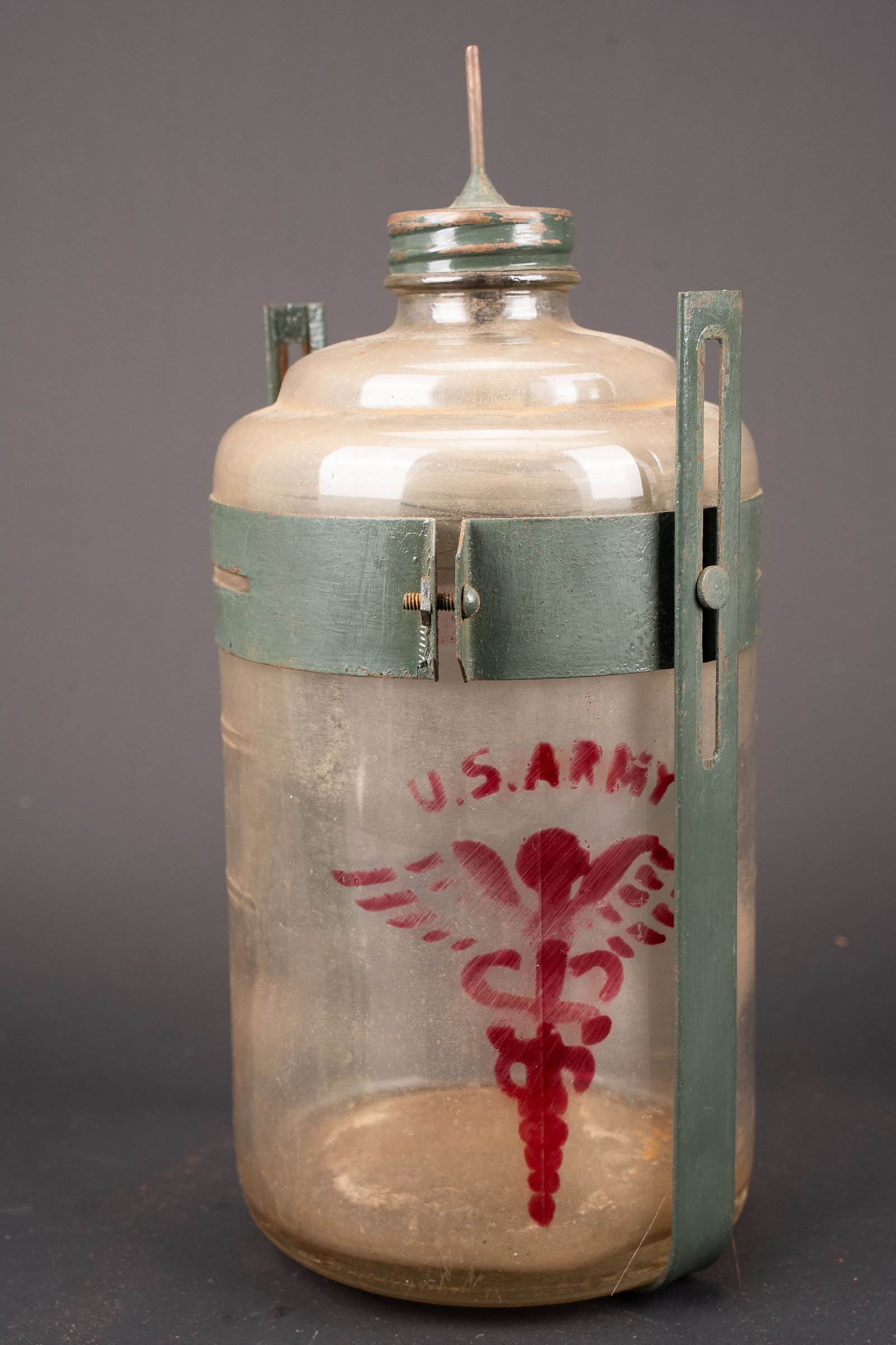 Flacon de perfusion US Army. US Army infusion bottle.: Flacon de perfusion US Army. En verre. Bel insigne de lUS army peint. Armature en metal complete. Bouchon complet avec son aiguille qui permet de fixer le tuyau decoulement. Hauteur avec laiguille 30 