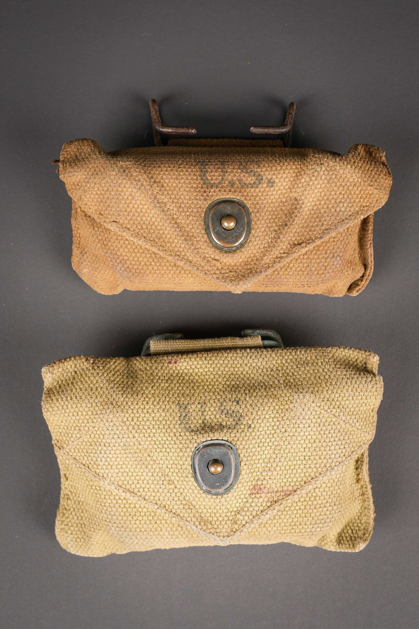 Pochettes et pansements US. US Army pouches and dressings.: Pochette et pansement US. Comprenant une pochette en toile OD3, beau marquage US sur le rabat, bouton pression fonctionnel, le crochet de fixation au ceinturon est present. Fabrication Boyt, date illi