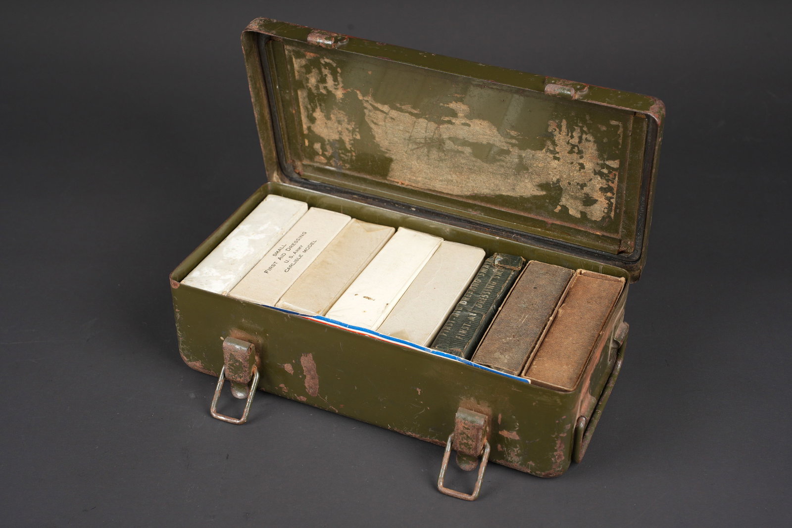 Caisse First Aid de vehicule. US Army Vehicle First Aid case.: Caisse First Aid de vehicule. Boite en metal. Peinture et marquages fortement uses et frottes. Les poignees de transport sont presentes. Les crochets de fermeture sont fonctionnels. La notice dinventa