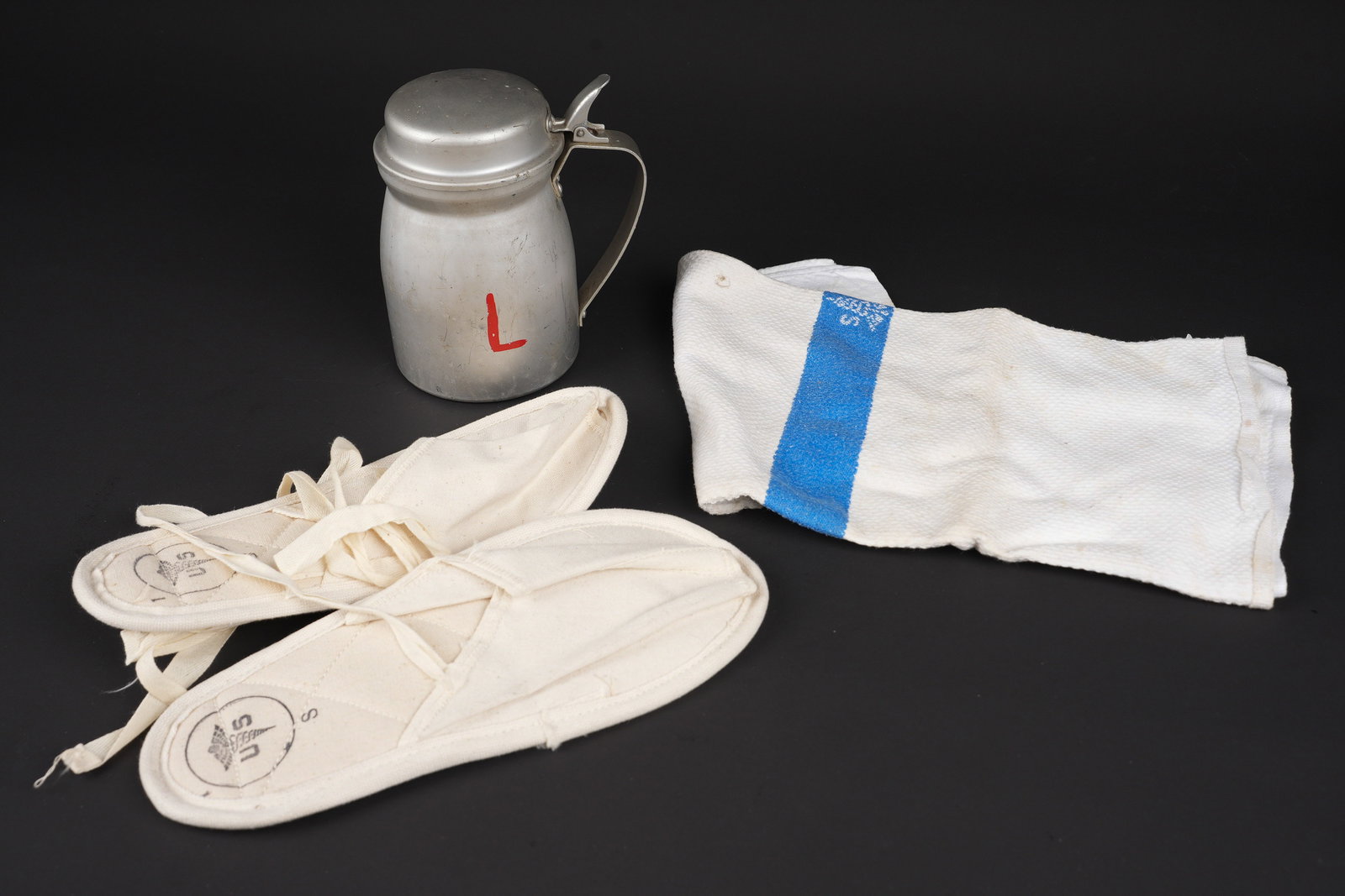 Accessoires medicaux US. US Army medical accessories.: Accessoires medicaux us. Comprenant une serviette nid dabeille en tissu coton blanc, bande bleue marquee US avec caducee. Etiquette du fabricant Cannon. Un pot a eau en aluminium, le couvercle est pre