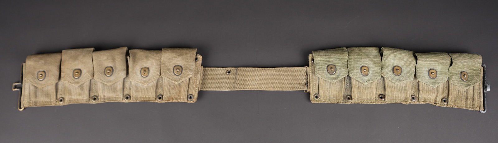 Ceinturon garand. M1 Garand cartridge belt.: Ceinturon Garand. En forte toile OD. Tous les boutons pressions sont fonctionnels. Bouclerie en metal et laiton. Sans marquages visibles. A noter une forte usure et patine de la piece, ainsi que des t