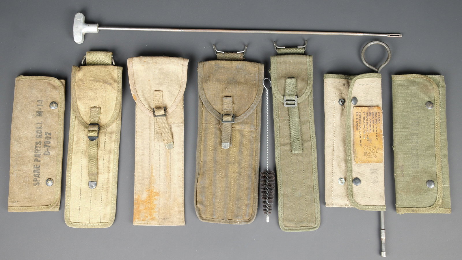 Accessoires darmement US. US ordnance accessories.: Accessoires darmement US. Comprenant trois modeles differents de baguettes de nettoyage. Une housse vide, en forte toile OD7, le crochet de fixation au ceinturon est present, marquee Case Cleaning