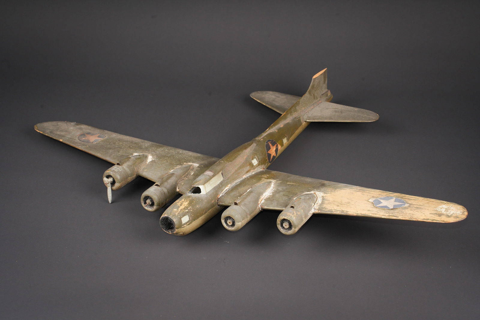 Maquette de bombardier USAAF. USAAF bomber model.: Maquette de bombardier USAAF. En bois, cockpit casse, ainsi quun morceau de la derive. Les helices sont egalement manquantes. Peinture kaki a 70%. Dimensions 48 x 46 cm. A noter une certaine usure et 