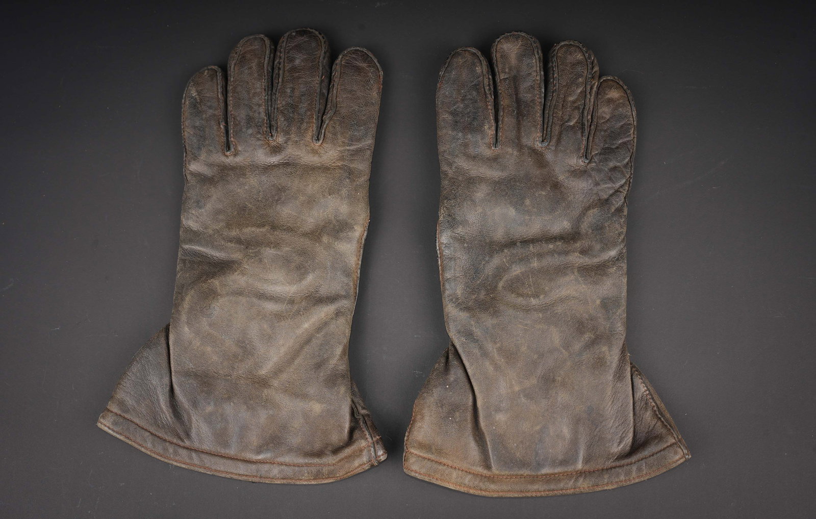 Gants de vol electrique. Electrically heated flight gloves.: Gants de vol electrique US. Paire homogene en cuir noir. Tous les boutons pressions sont fonctionnels. Interieur double en tissu blanc. Les prises electrique sont presentes. Etiquette du fabricant Gen