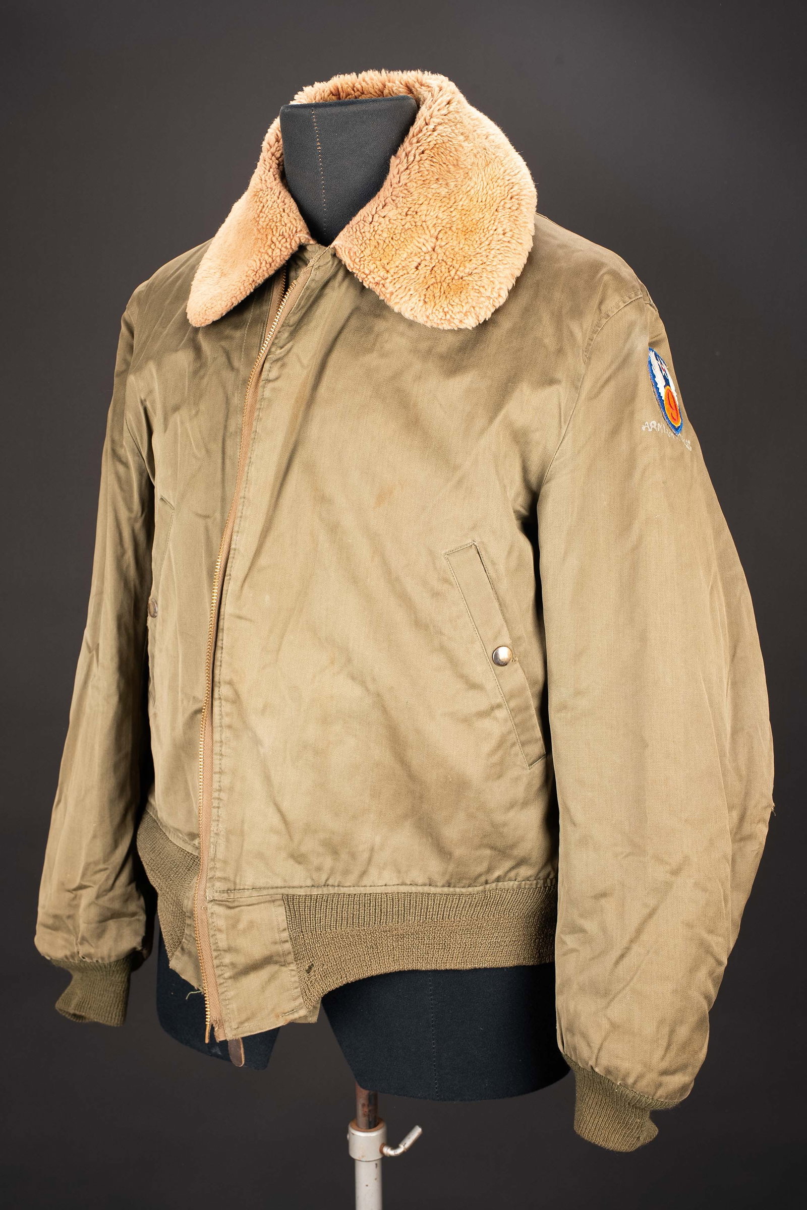 Blouson de vol A-15 US. US A-15 flight jacket.: Blouson de vol A-15. En popeline kaki. Fermeture eclaire fonctionnelle, fabrication Talon, tirette en toile complete. Col double de fausse fourrure. Les feutrines au bas des manches et de la veste son