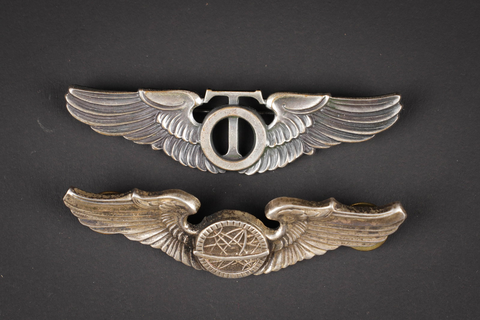 Brevet de pilote US. US pilot wings.: Brevets de pilote US. Comprenant un brevet de Navigator, couleur argent, Sterling, attaches completes. Un brevet de Technical Observer, couleur argent, Gemsco NY. Attache complete. A noter une certain