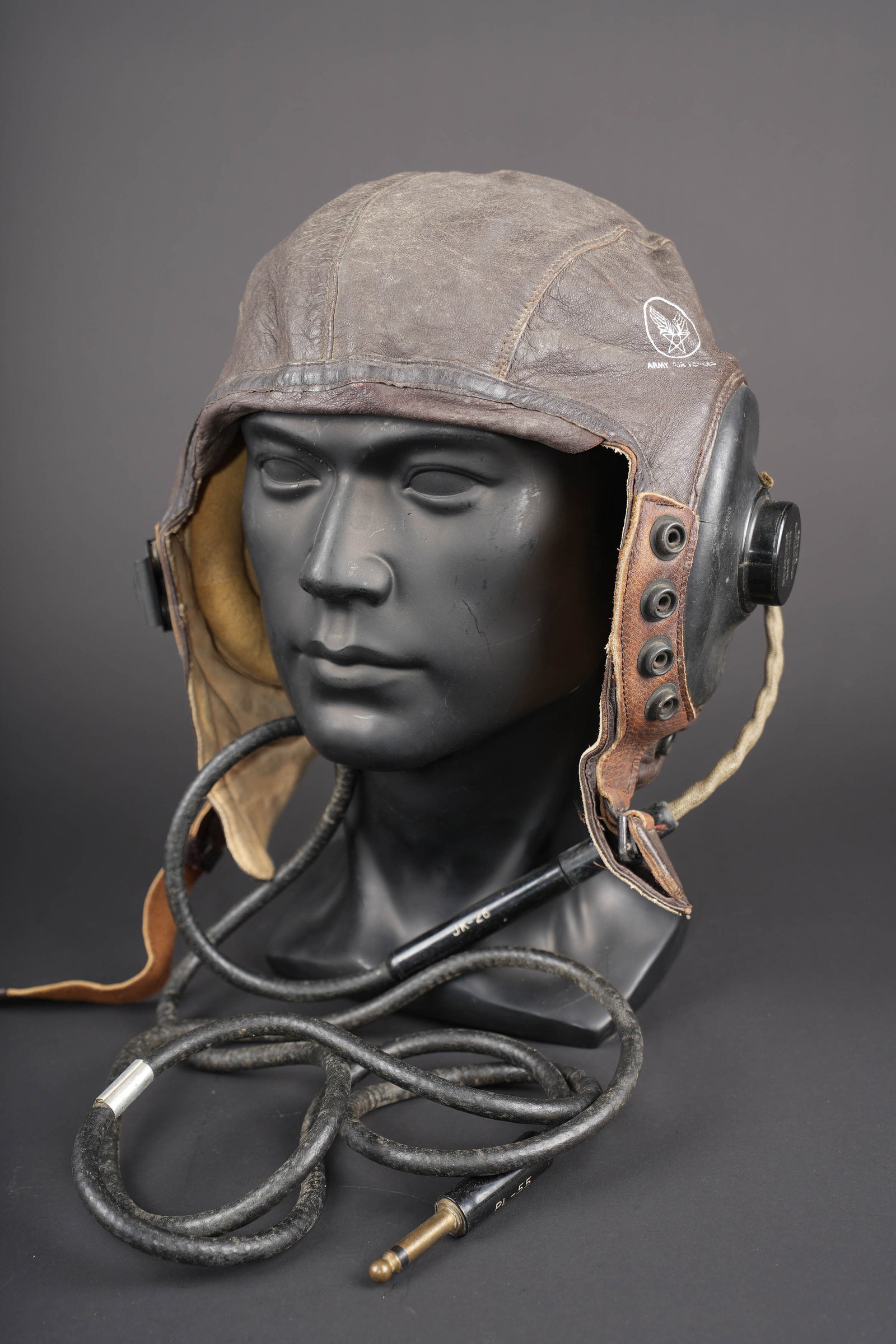 Bonnet de vol A-11 US. US A-11 flight helmet.: Bonnet de vol A-11. En cuir marron souple. Tampon de lArmy Air Forces imprime sur le cote du bonnet. Les proteges ecouteurs sont en caoutchouc noir. Toutes les sangles sont presentes. Jugulaire en