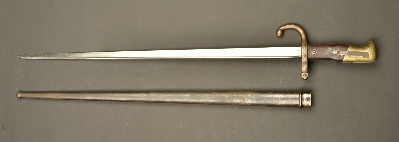 Baionnette francaise Gras Mlle 1874. French Gras Model 1874 bayonet: Baionnette francaise Gras Mlle 1874. Belle lame a dos plat marquee de la manufacture de Chatellerault 1877. Plaquettes bois. Bouton ressort fonctionnel. Arme et fourreau avec numeros differents. Fourr