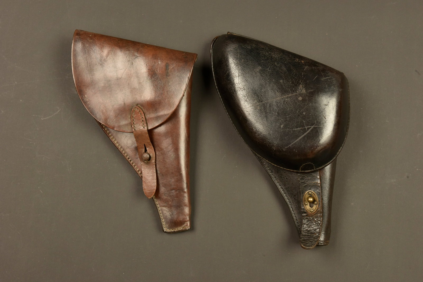 Lot de deux etuis pour revolver francais 1873 et 1892. Lot of two holsters for French Model 1873 and: Lot de deux etuis pour revolver francais 1873 et 1892. Un bel etui jambon pour 1873, en cuir noir, avec son compartiment a cartouches. Et un etui simplifie en cuir marron, avec compartiment a cartouch
