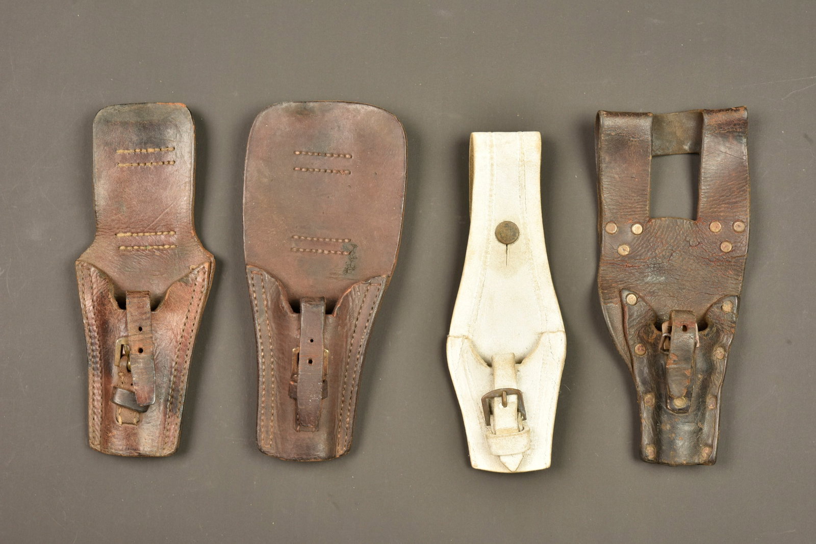 Lot de 4 portes baionnette francais. Lot of four French bayonet frogs: Lot de 4 portes baionnette francais. 2 pour la baionnette Berthier 1892, dont un plus etroit. Un pour la baionnette Lebel 1886 en cuir rivete. Un en buffle blanc. Les sangles de maintien et boucles so