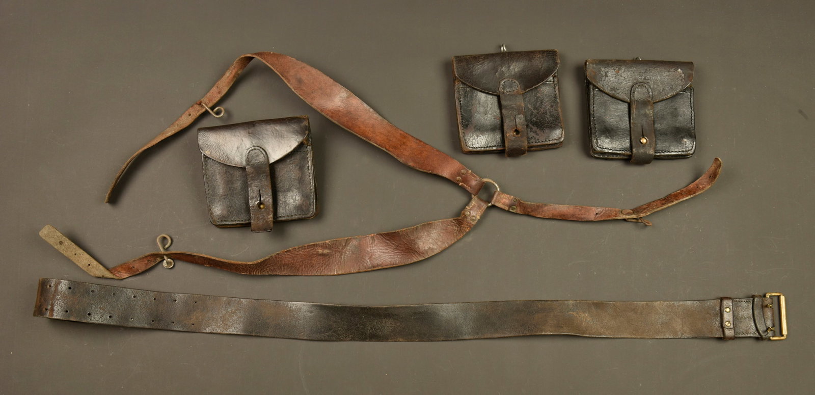 Ensemble brelage francais. French webbing equipment set: Ensemble brelage francais. Ceinturon Mle 1903 a passant rivete, bretelles en cuir fauve a 8 et 9 trous avec crochets fer brut, et 3 cartouchieres en cuir fonce. Usure d usage, patine. French webbing e