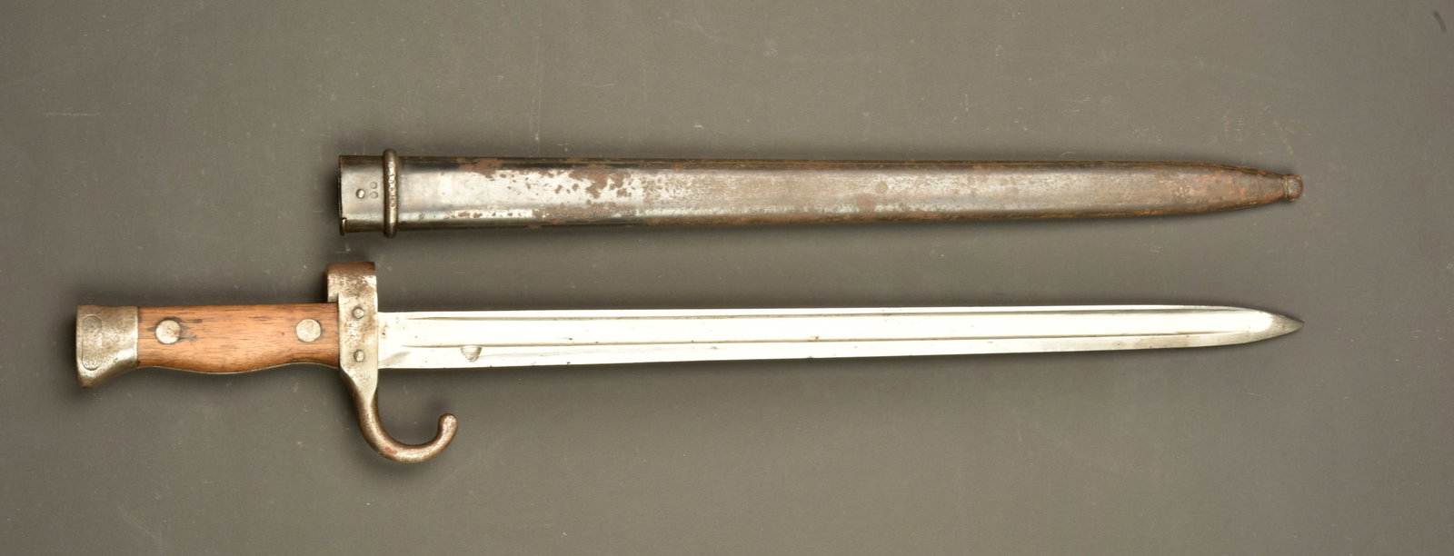 Baionnette francaise Mle 1892 au memes numeros. French Model 1892 bayonet with matching numbers: Baionnette francaise Mle 1892 au memes numeros. Lame a dos plat marquee de la manufacture de Chatellerault 1893. Plaquettes bois. Bouton ressort fonctionnel. Arme et fourreau au meme numero. Fourreau 