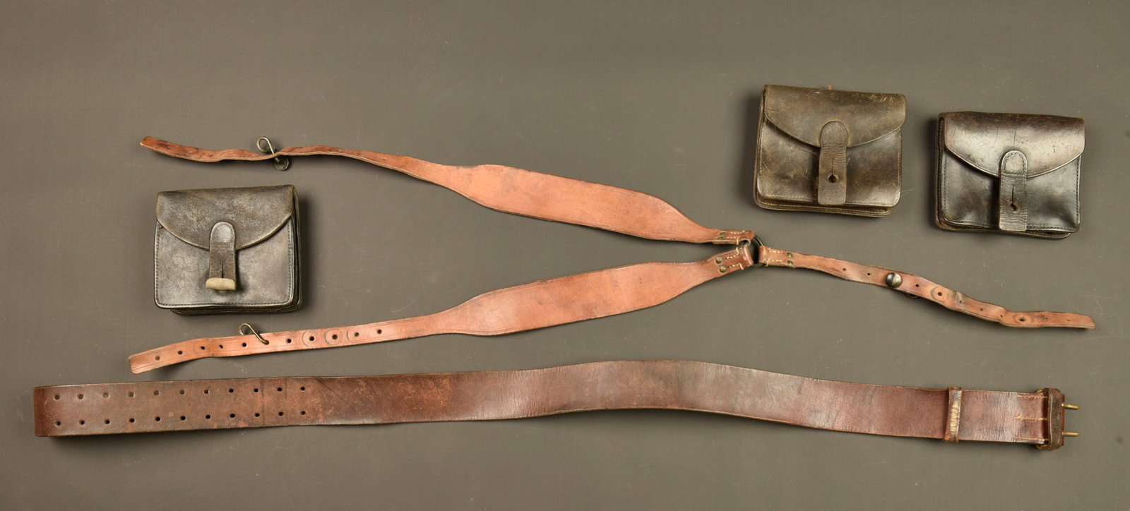 Ensemble brelage francais. French webbing equipment set: Ensemble brelage francais. Ceinturon Mle 1903 a boucle laiton, bretelles en cuir fauve a 11 trous avec crochets fer, et 3 cartouchieres en cuir fonce. Usure d usage, patine. French webbing equipment s