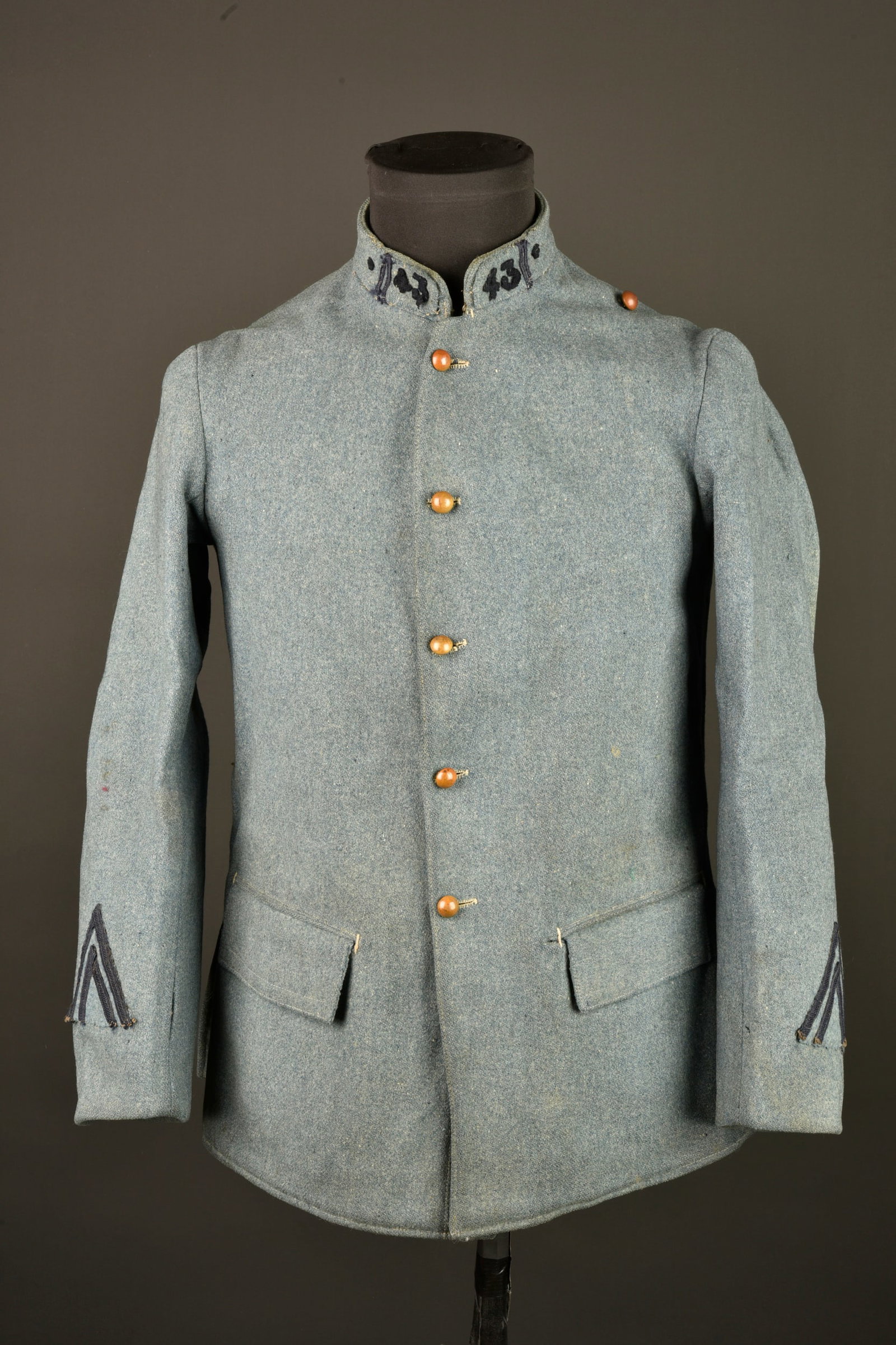 Vareuse bleu horizon modele 1915 du 43e de Ligne. Model 1915 horizon blue tunic of the 43rd Line: Vareuse bleu horizon modele 1915 du 43e de Ligne. Vareuse en drap bleu horizon, 2 poches de hanche internes, fermant par 5 petits boutons hemispheriques dores. Petit col droit avec patte en drap du fo