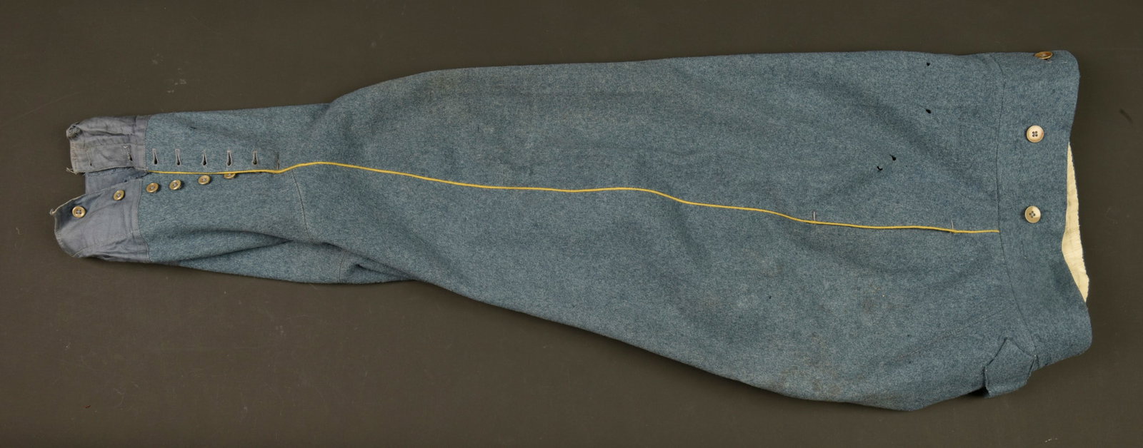 Culotte bleu horizon d un officier d infanterie. Horizon blue infantry officer’s breeches: Culotte bleu horizon d un officier d infanterie. Fabrication tailleur en drap de laine bleu horizon, non renforcee, passepoil jonquille, martingale, doublure tissu raye. Nombreux trous et lechures de 