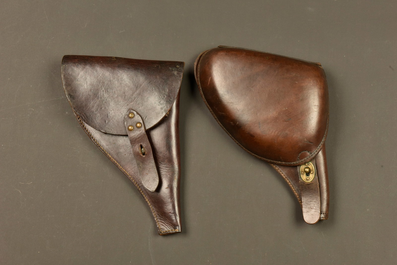 Lot de deux etuis pour revolver francais 1892. Lot of two holsters for French Model 1892 revolver: Lot de deux etuis pour revolver francais 1892. Un bel etui jambon pour 1892 avec sa poche a cartouches. Et un etui simplifie rivete avec tampon de reception de 1917. Les deux sans bretelle. Bon etat, 
