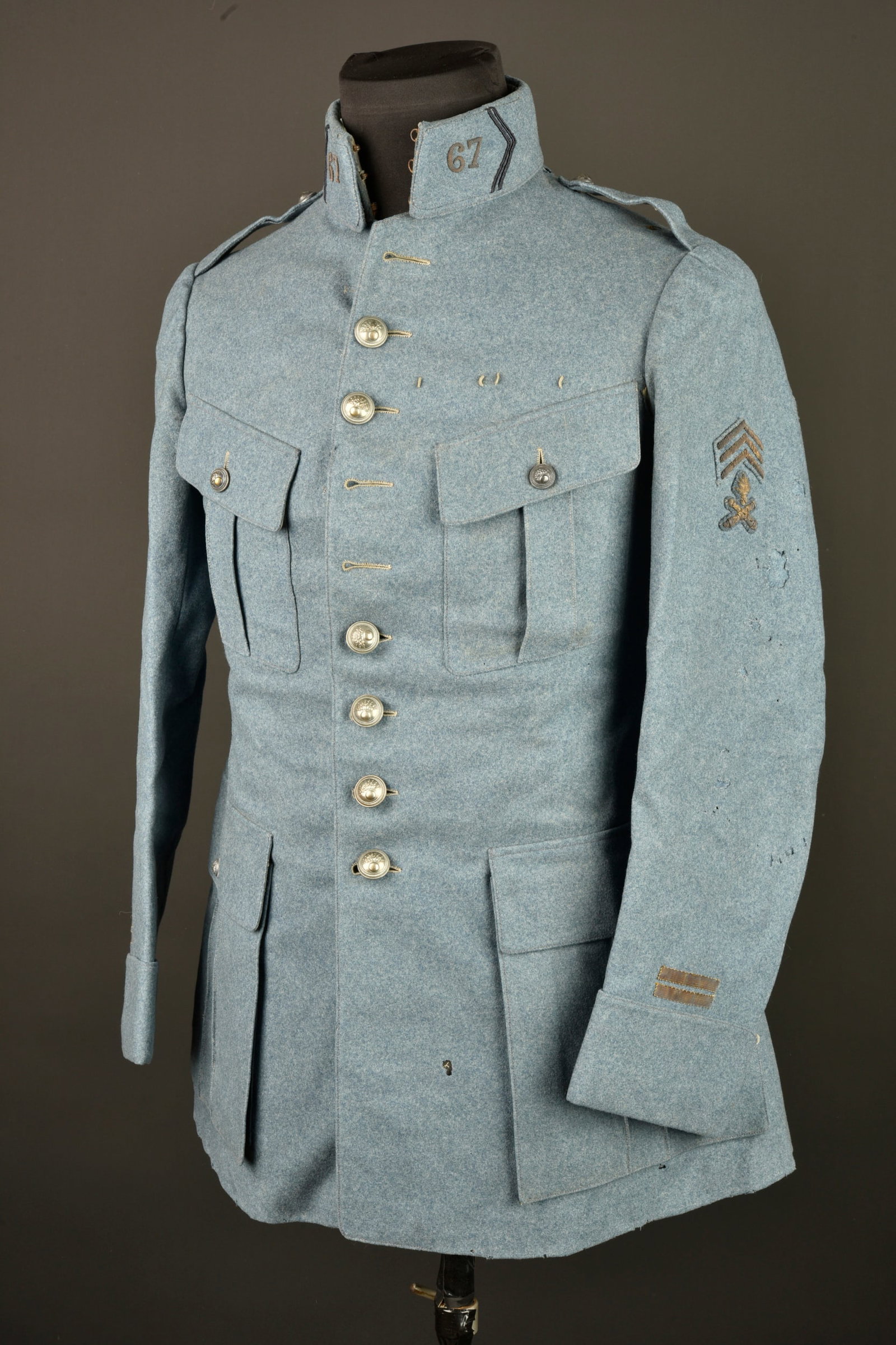Tunique bleu horizon d un lieutenant mitrailleur du 67e RI. Horizon blue tunic of a machine gun: Tunique bleu horizon d un lieutenant mitrailleur du 67e RI. En drap bleu horizon, veste a 4 poches a rabats, plaquees dont celles de poitrine a soufflets. Les boutons de fermeture sont presents. Les d
