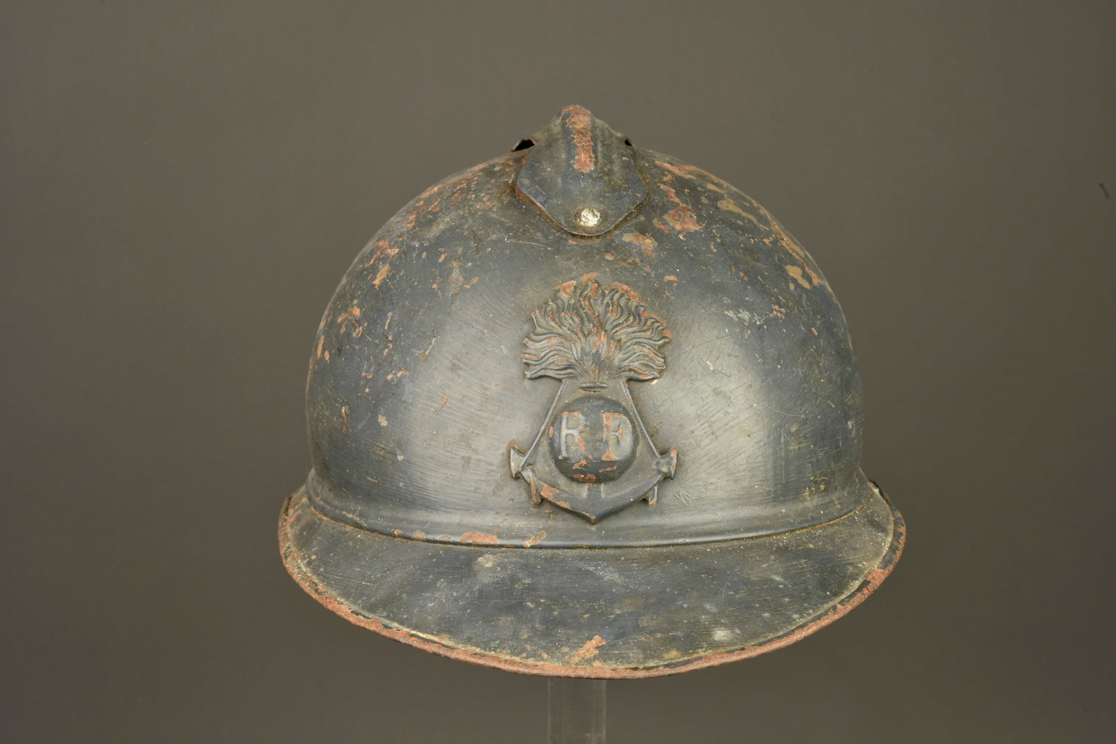 Casque Adrian de l infanterie coloniale. Colonial Infantry Adrian helmet: Casque Adrian de l infanterie coloniale. Casque avec l attribut a la grenade et ancre de marine de l infanterie coloniale. Peinture bleu horizon fonce appliquee au pinceau par-dessus la livree d usine