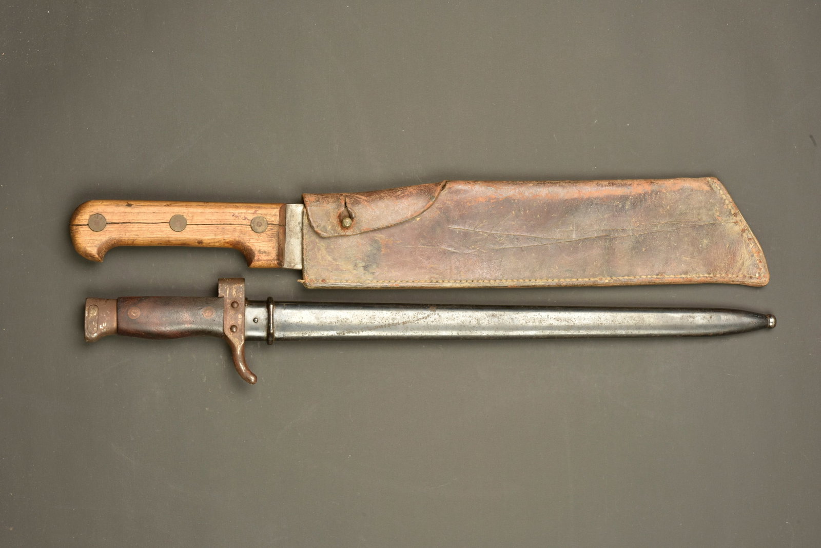 Baionnette Berthier 1892 et machette francaise. Berthier Model 1892 bayonet and French machete: Baionnette Berthier 1892 et machette francaise. Baionnette modele 1892, bouton ressort fonctionnel, fourreau bronze, numero different de celui de l arme. Oxydation superficielle. Une machette ou coupe