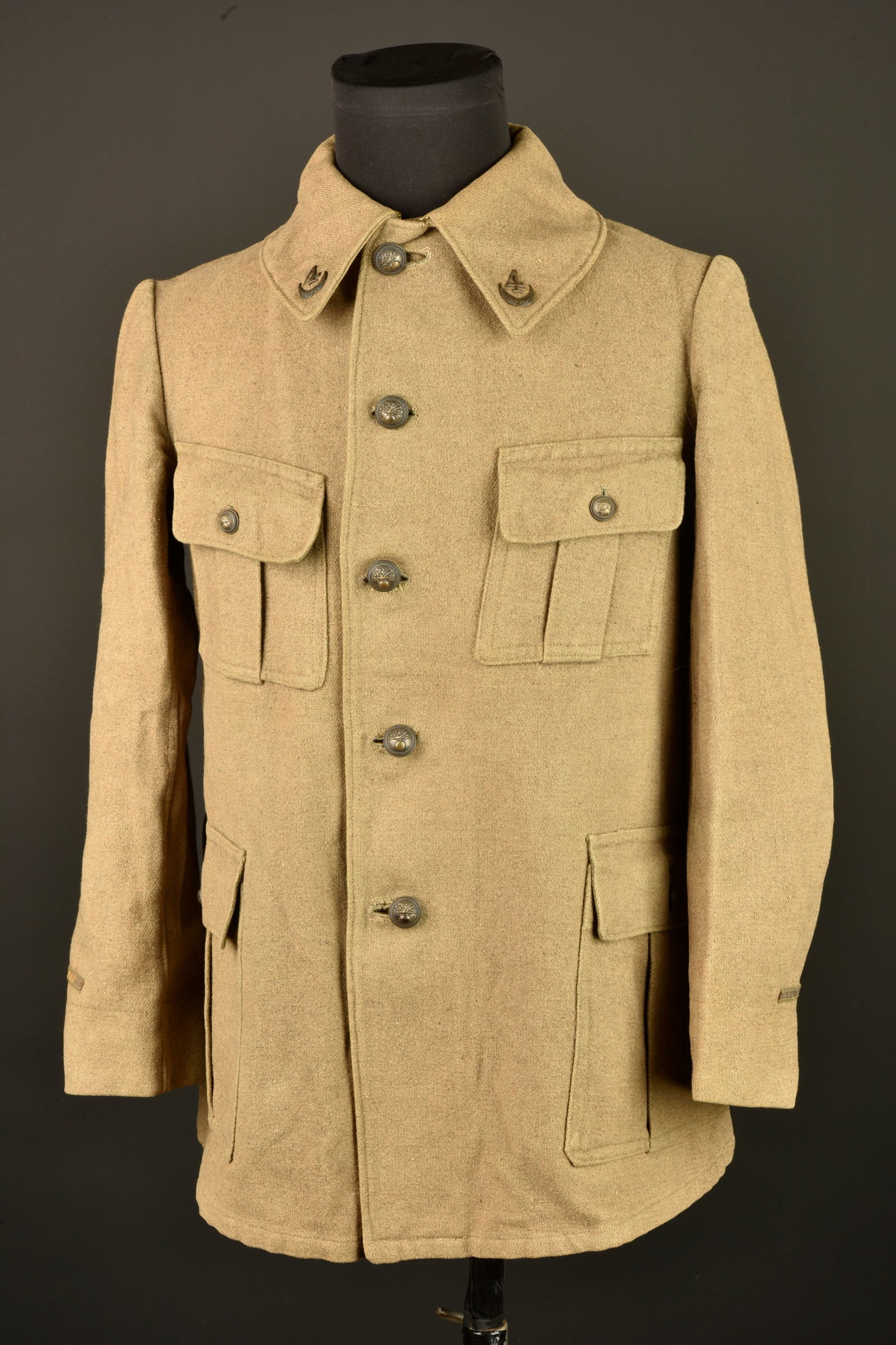 Vareuse kaki d officier du 4e Zouaves. Khaki officer’s tunic of the 4th Zouaves Regiment: Vareuse kaki d officier du 4e Zouaves. En drap kaki, fermant par 5 boutons, 4 poches plaquees a soufflet, col chevaliere avec attributs du 4e Zouaves en metal dore, etiquette A La Belle Jardiniere. Pa