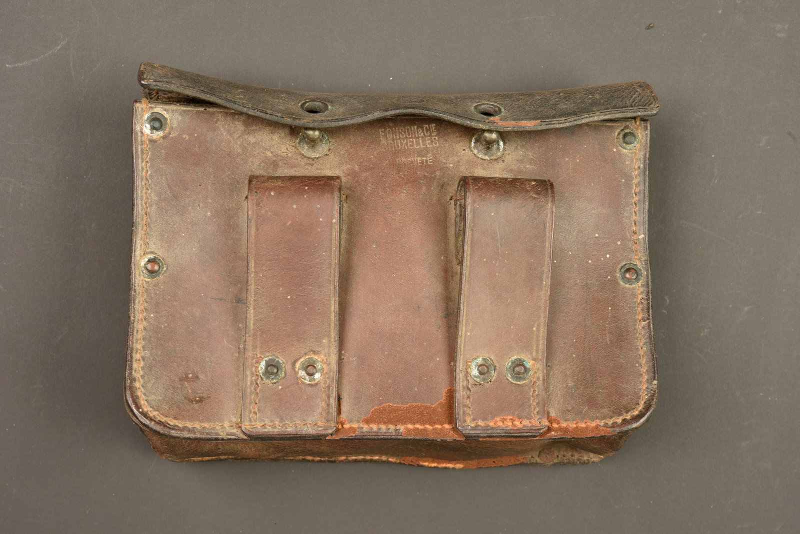 Cartouchiere ventrale belge. Belgian front mounted cartridge pouch: Cartouchiere ventrale belge. Rare cartouchiere belge, en cuir marron avec ses passants de ceinturon, son rabat a œillets s adaptant sur des tenons laitons, son couvercle interne, modele sans crochets
