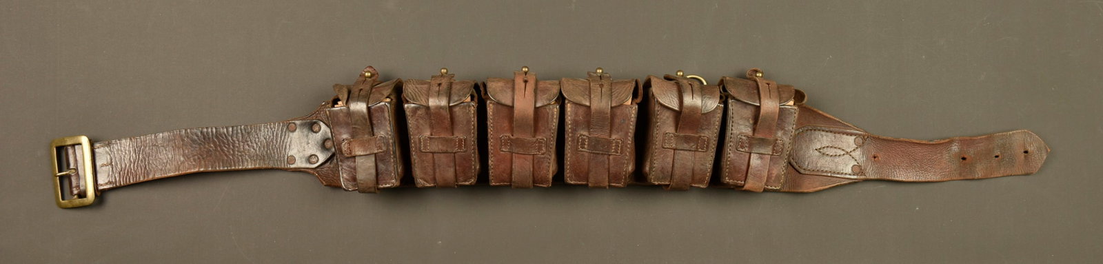 Rare ceinturon cartouchiere belge Gomez. Rare Belgian Gomez cartridge belt: Rare ceinturon cartouchiere belge Gomez. Rare et authentique ceinturon cartouchiere Gomez, en cuir marron, a 6 poches a cartouches. Toutes les sangles sont en bon etat, les anneaux, crochets et boucle