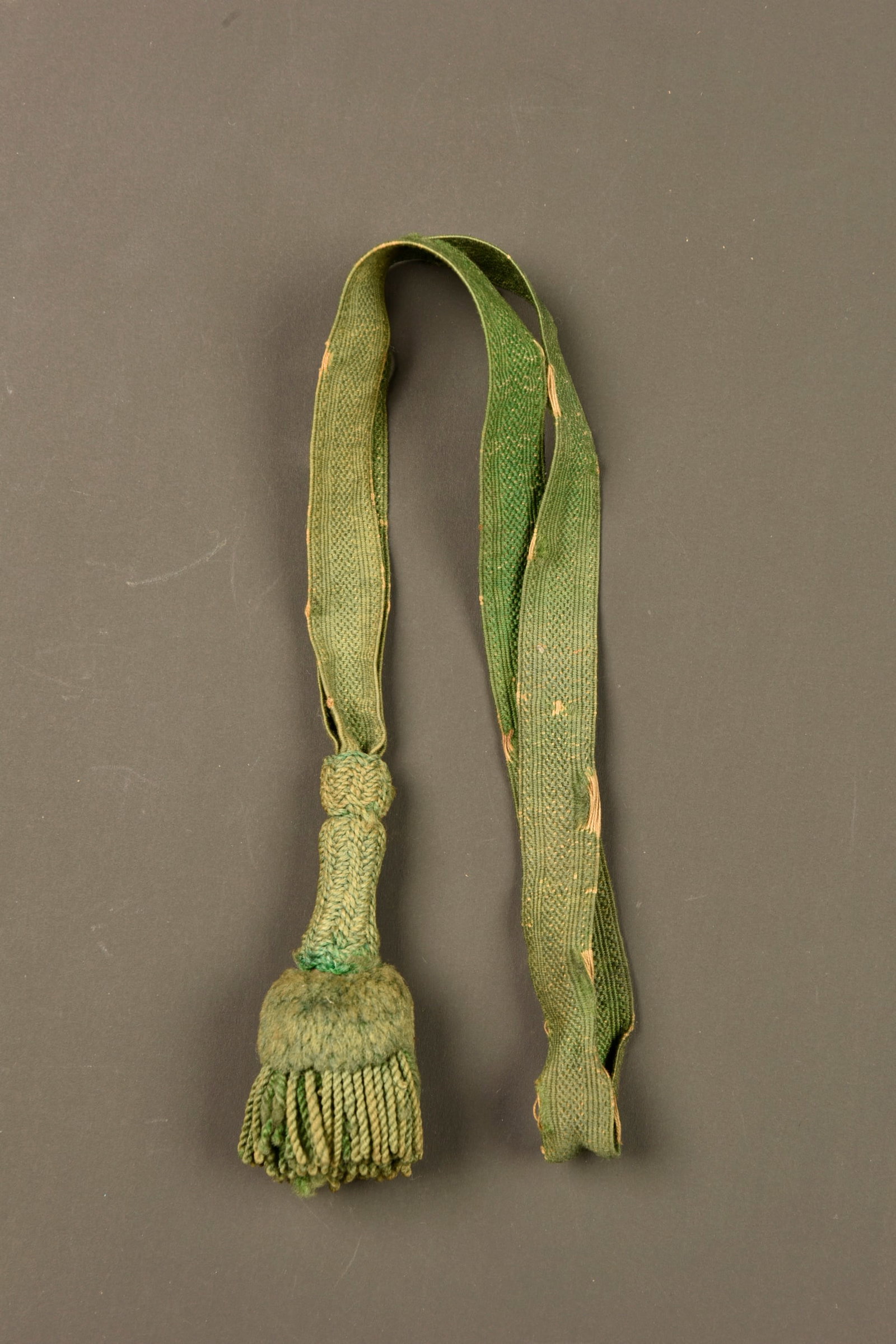Dragonne de chasseur a pied allemand. German light infantry sword knot: Dragonne de chasseur a pied allemand. Troddel troupe de Jager, de couleur verte, usure, legerement insole. German light infantry sword knot. Troddel for Jager enlisted personnel in green colour. Worn 