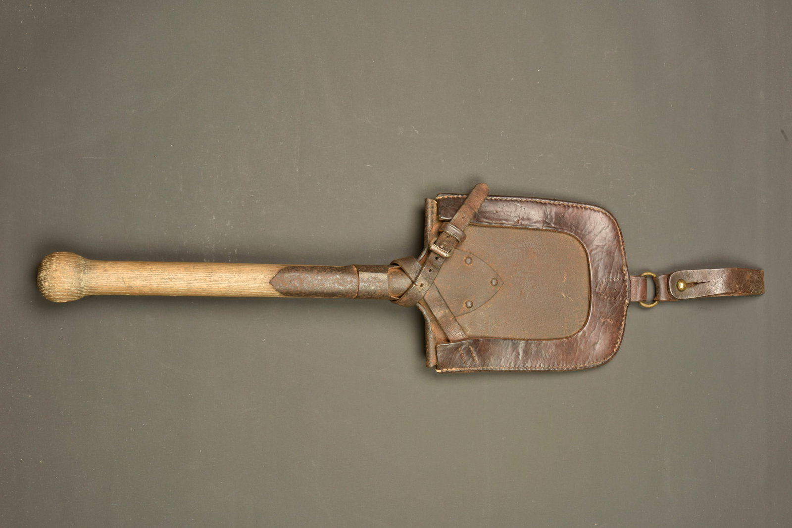 Pelle individuelle allemande avec etui precoce. German entrenching shovel with early carrier: Pelle individuelle allemande avec etui precoce. Pelle droite, oxydation. Manche bois en bon etat, fente pour attache de la pelle sur chariot ou crochet dans abri. Bel etui en cuir marron, ancien model