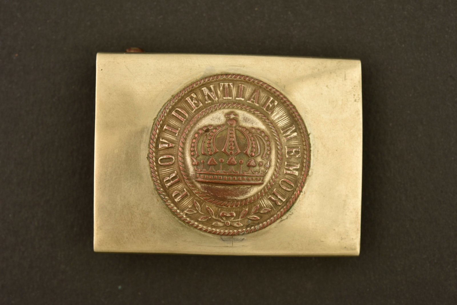 Boucle saxonne couleurs inversees pour 100e Leib Garde ou Jager. Saxon buckle with reversed colours: Boucle saxonne couleurs inversees pour 100e Leib Garde ou Jager. Belle boucle a plateau maillechort, macaron central Providentiae Memor, axe a ardillons en laiton. Bon etat, usure, patine. Saxon buckl