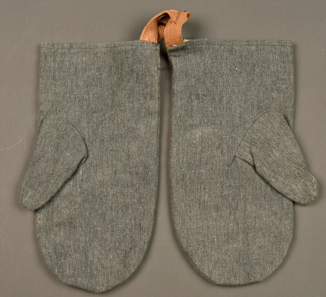 Paire de moufles allemandes regimentees. Pair of regimentally marked German mittens: Paire de moufles allemandes regimentees. En drap gris doublees de coton. Tampon d unite a l interieur d un bataillon de Landwehr ou Landsturm. Avec leurs sangles en toile beige. Tres bon etat. Pair of