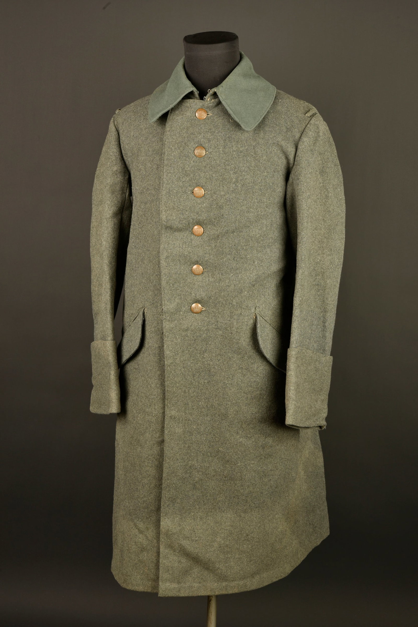 Capote allemande feldgrau Mantel M1915. German Model 1915 feldgrau greatcoat: Capote allemande feldgrau Mantel M1915. En fort drap feldgrau, dans sa longueur, fermant par 6 boutons a la couronne, peints en feldgrau. Quatre ou cinq petits trous de mites minimes. Possiblement leg