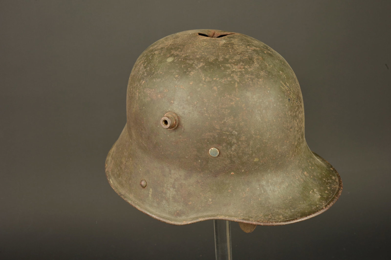 Casque allemand M1916 a impact. German Model 1916 helmet with impact damage: Casque allemand M1916 a impact. Stahlhelm M16 peint feldgrau, fabricant Bing taille 64. Un impact traversant sur le dessus. Bandeau cuir, coiffe absente. Un trou d accroche au mur sur la nuquiere. Usu
