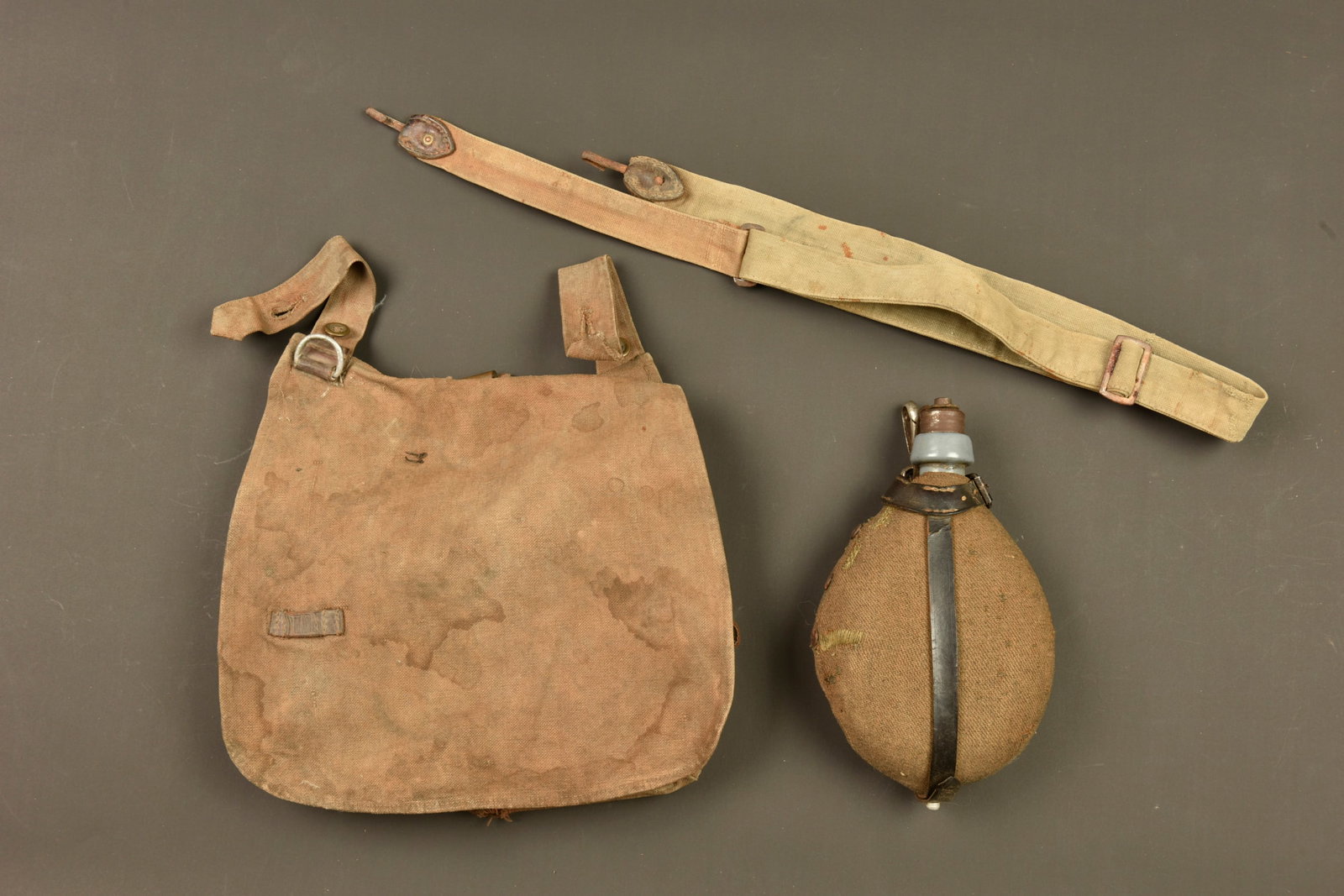 Equipement allemand sac a pain, bretelle et bidon. German equipment set including bread bag, sling: Equipement allemand sac a pain, bretelle et bidon. Brotbeutel en toile cachou, regimente 65R et date 1897, complet, usure, taches. Une bretelle en toile feldgrau, passant tissu manquant, boucleries et