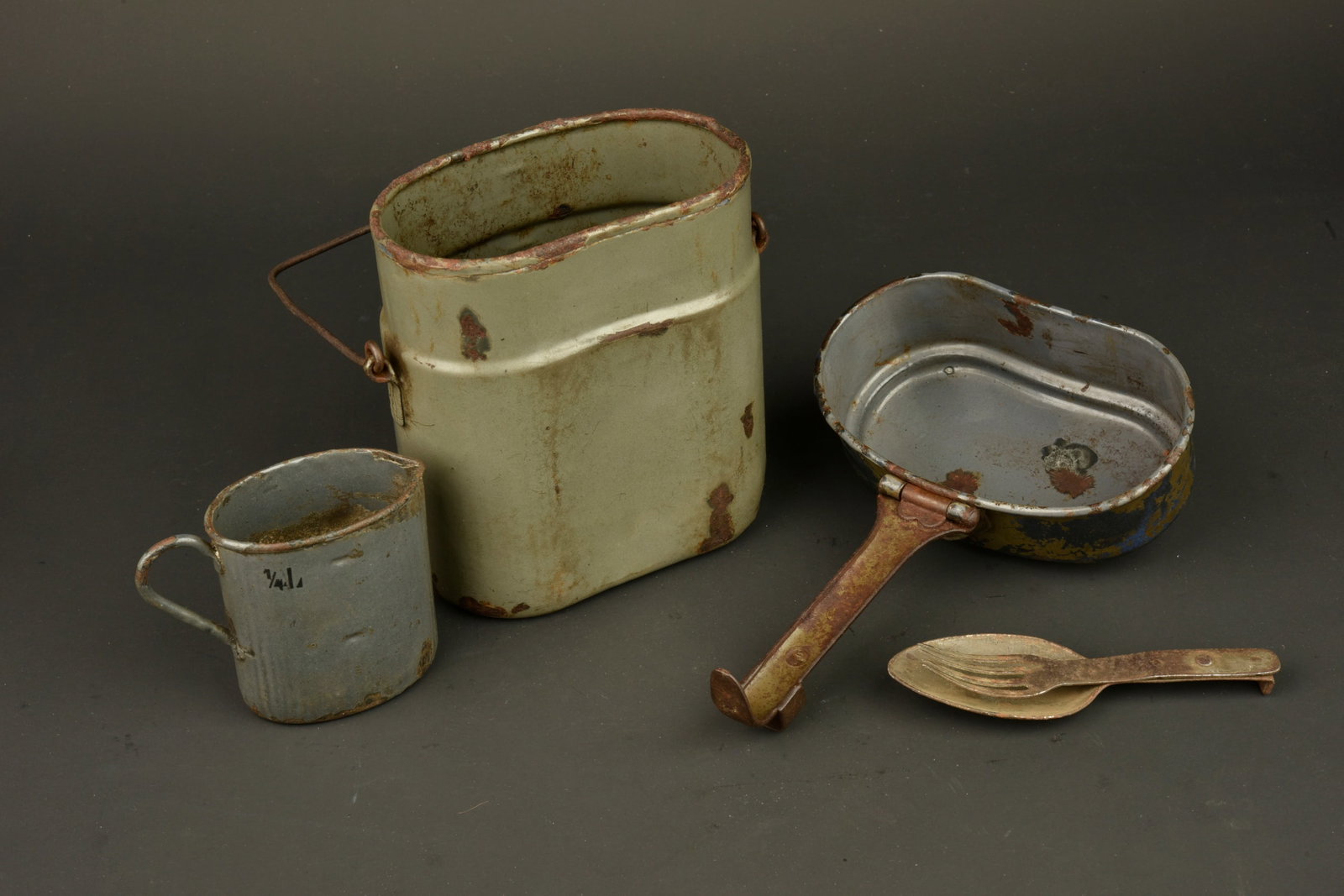 Gamelle, quart et couverts allemands. German mess tin, drinking cup and cutlery set: Gamelle, quart et couverts allemands. Gamelle emaillee, haut et bas depareilles, bas Silesia 1916. Quart emaille feldgrau fabricant Lamprecht 1917, couverts combines en fer. Usure d usage, patine. Ger