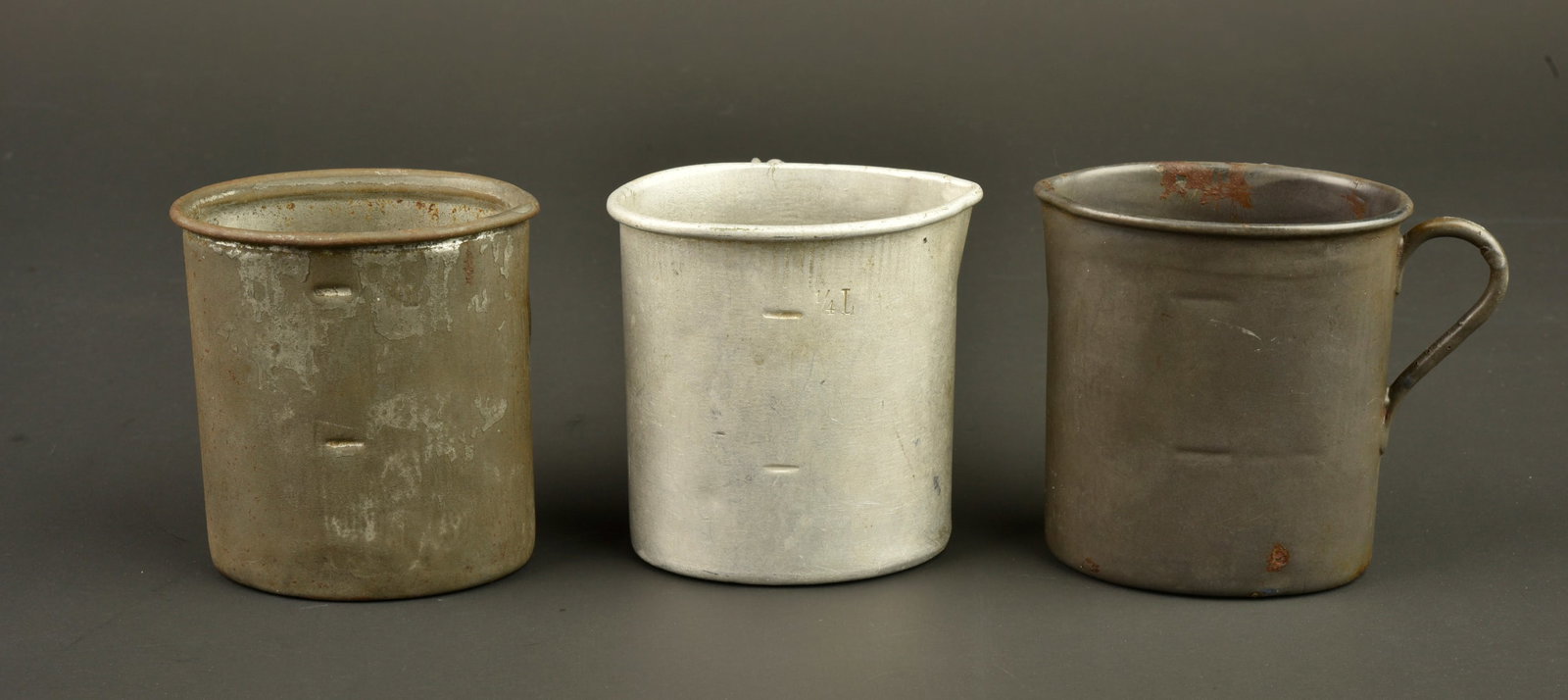 Lot de 3 quarts allemands de differents modeles. Lot of three German drinking cups of different: Lot de 3 quarts allemands de differents modeles. Un quart en aluminium, avec un peu courant marquage au dessous, du fabricant Flohr de Koln en 1915, un modele ersatz en fer etame BING 1914 et un quart