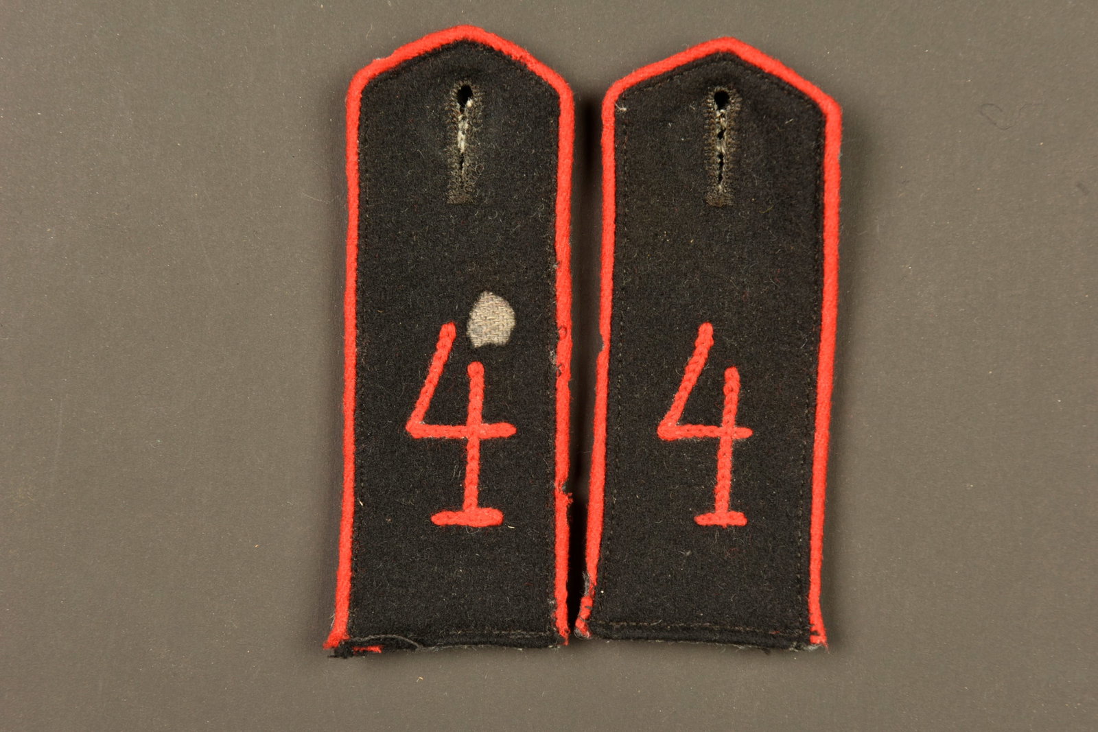 Paire de pattes d epaule M1915 du 4e bataillon de Pionnier. Pair of Model 1915 shoulder straps of: Paire de pattes d epaule M1915 du 4e bataillon de Pionnier. Drap noir, chiffre et passepoil rouge, dessous feldgrau. Un trou sur le drap noir sur l une. Pair of Model 1915 shoulder straps of the 4th P