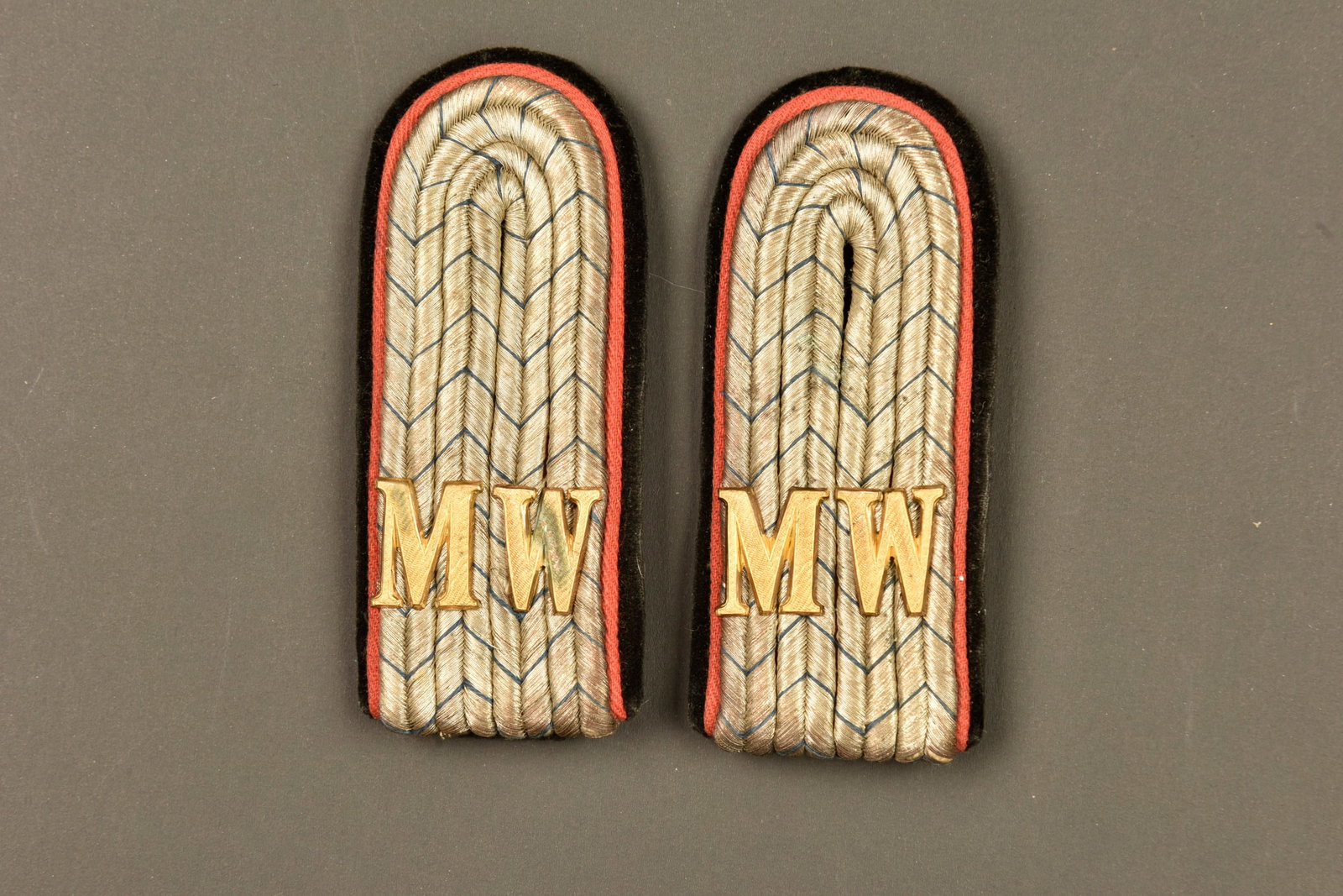 Paire de pattes d epaule d un officier de Minen Werfer bavarois. Pair of shoulder straps of a: Paire de pattes d epaule d un officier de Minen Werfer bavarois. Modele 1915, tresse argent avec fils bleus, couleur de la Baviere. Passepoil rouge et dessous velours noir avec contre patte. Chiffres 