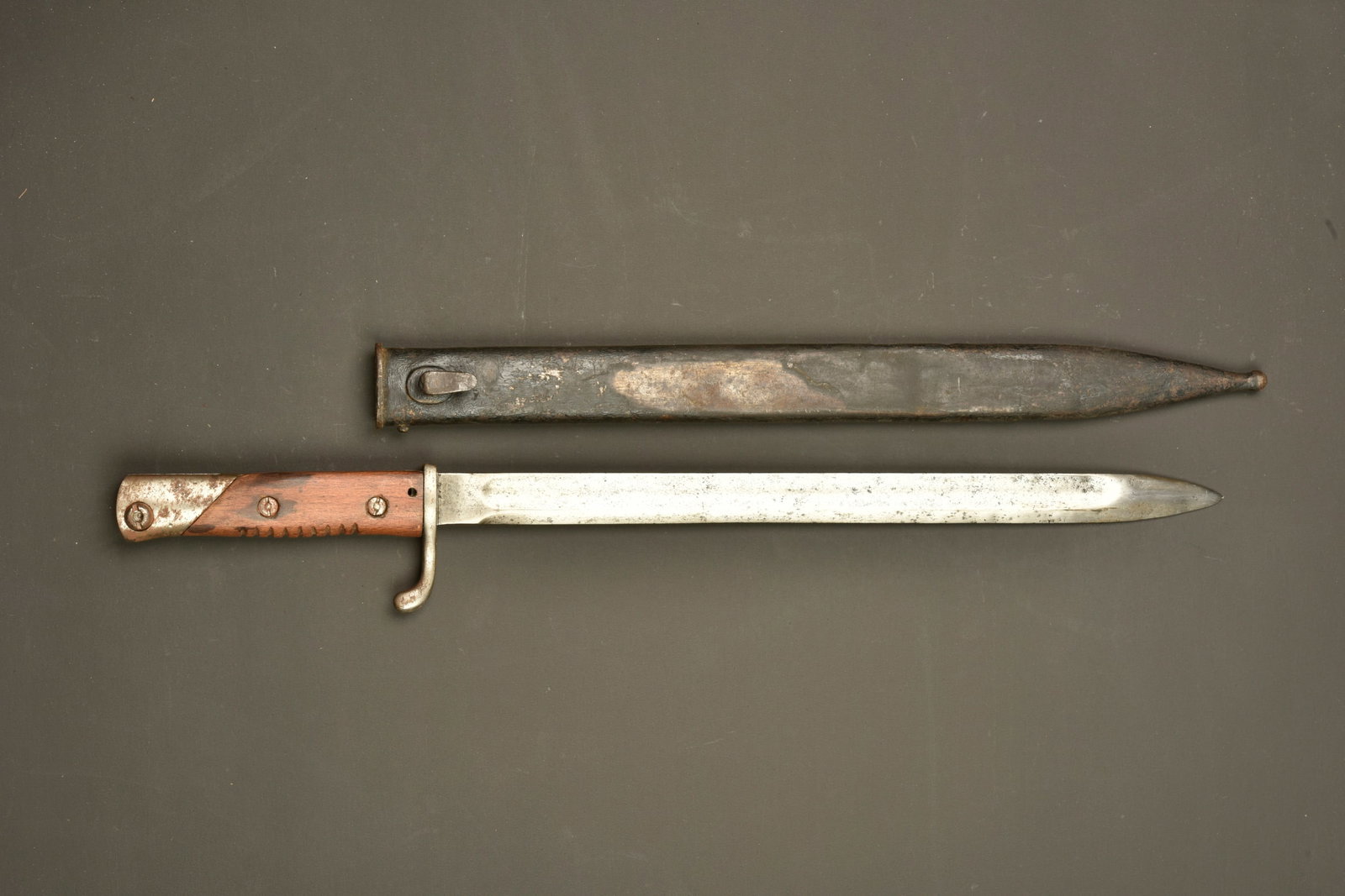 Baionnette allemande Gottscho dite de mitrailleur. German Gottscho bayonet, known as the machine: Baionnette allemande Gottscho dite de mitrailleur. Lame droite a dos plat. On distingue encore le logo de Gottscho. Arme usee et nettoyee. Poignee bois refaite. Bouton ressort fonctionnel. Fourreau fe