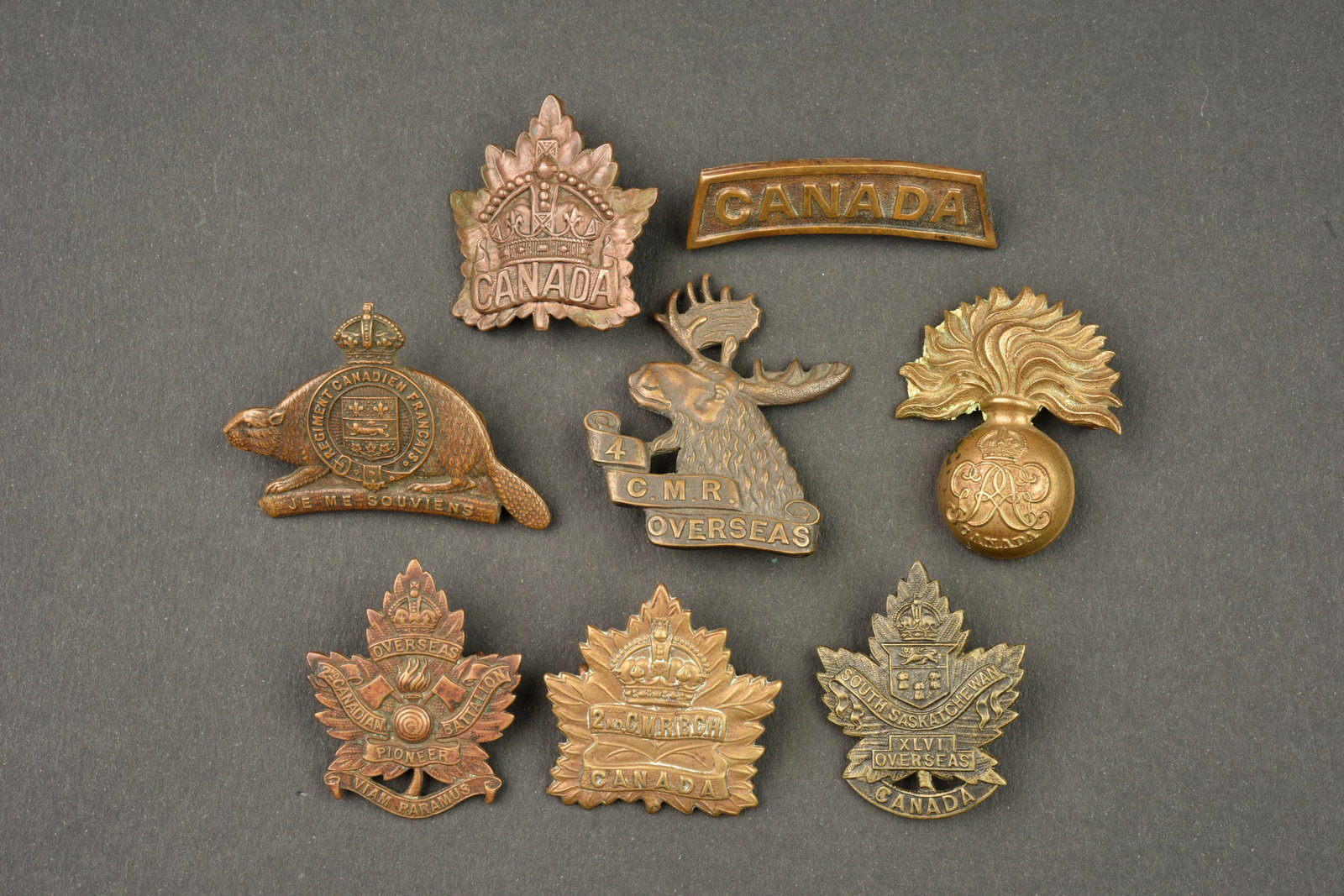 Lot de 8 insignes Canadiens. Lot of 8 Canadian badges: Lot de 8 insignes Canadiens. 5 cap badges 1ere guerre dont Canadiens Francais, 2nd et 4th Mounted Rifles, 2nd Pioneer..3 ont des attaches defectueuses. Usure d usage, patine. Lot of 8 Canadian badges.