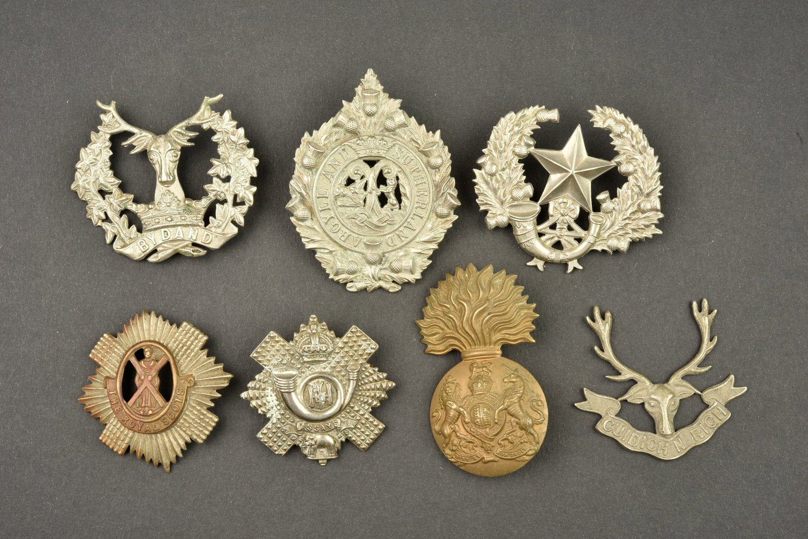 Lot de 7 cap badge Ecossais. Lot of 7 Scottish cap badges.: Lot de 7 cap badge Ecossais. Lot de 7 insignes de coiffure d infanterie ecossaise. Deux ont une de leurs 2 attaches manquante, un troisieme n en a plus. Usure d usage, patine. Lot of 7 Scottish cap