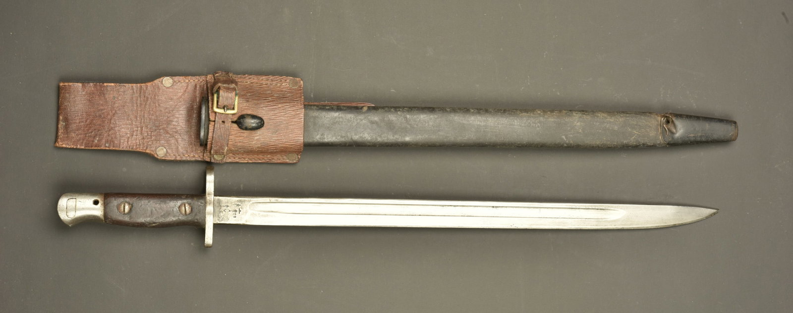 Baionnette anglaise 1907 avec fourreau a impact et porte fourreau cuir. British Pattern 1907 bayonet: Baionnette anglaise 1907 avec fourreau a impact et porte fourreau cuir. Belle lame du fabricant Remington datee 11 1915, avec plusieurs poincon d inspection. Plaquettes bois. Bouton ressort fonctionne
