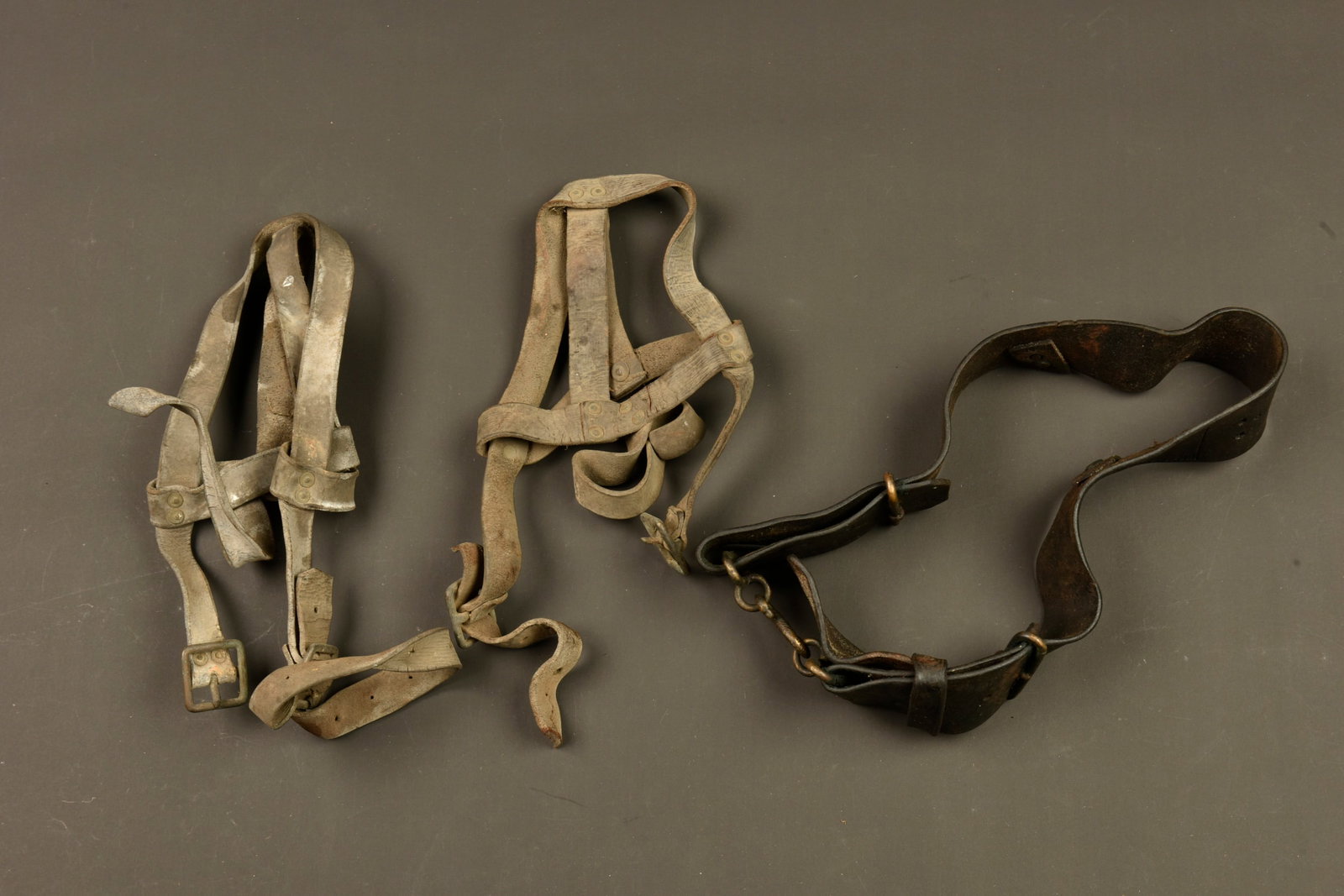 Equipement anglais en cuir pattern 1914. British Pattern 1914 leather equipment: Equipement anglais en cuir pattern 1914. Lot d equipements retrouves dans le secteur Artois comprenant un ceinturon avec sa boucle serpent, les sangles arrieres et boucles de suspension manquantes. De