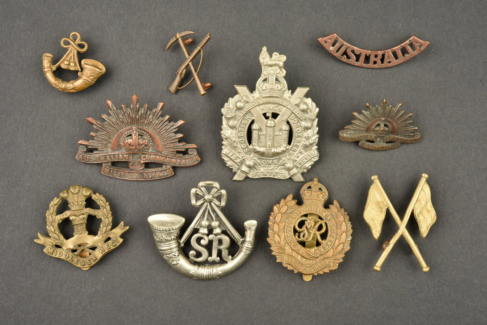 Lot de 10 insignes australiens et anglais. Lot of 10 Australian and British badges: Lot de 10 insignes australiens et anglais. Cap badge Cameronians 2nd Scottish Rifles, Scottish Borderers, Cap badge, collar et title australien et divers, tous avec leurs attaches. Usure d usage, pati