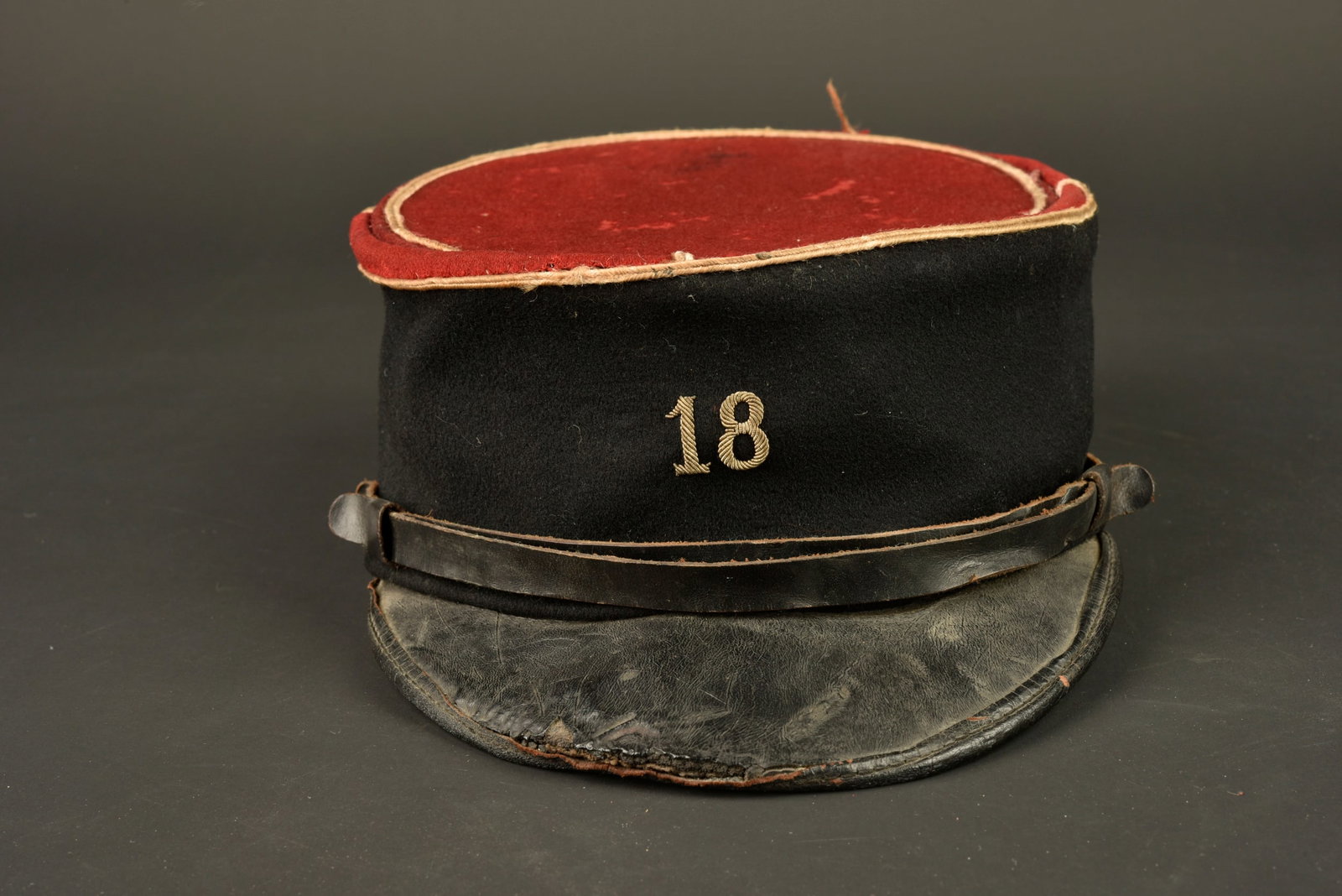 Kepi 18eme SIM.Kepi of the 18th SIM.: Kepi 18eme SIM. Confectionne en drap ecarlate, bandeau en drap noir, passepoil blanc, chiffre 18 brode cannetille argentee. La 18eme section d infirmiers militaires etait stationnee a Bordeaux.