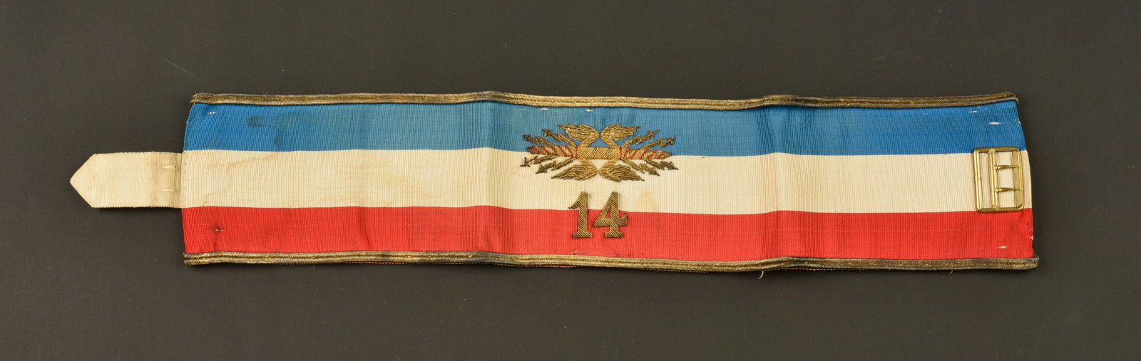Brassard d etat major du 14eme corps d armee. General staff armband of the 14th Army Corps.: Brassard d etat major du 14eme corps d armee. Confectionne en soie tricolore, brode en son centre des foudres de l etat major surmontant le chiffre 14. Brassard borde de deux galons dores et double